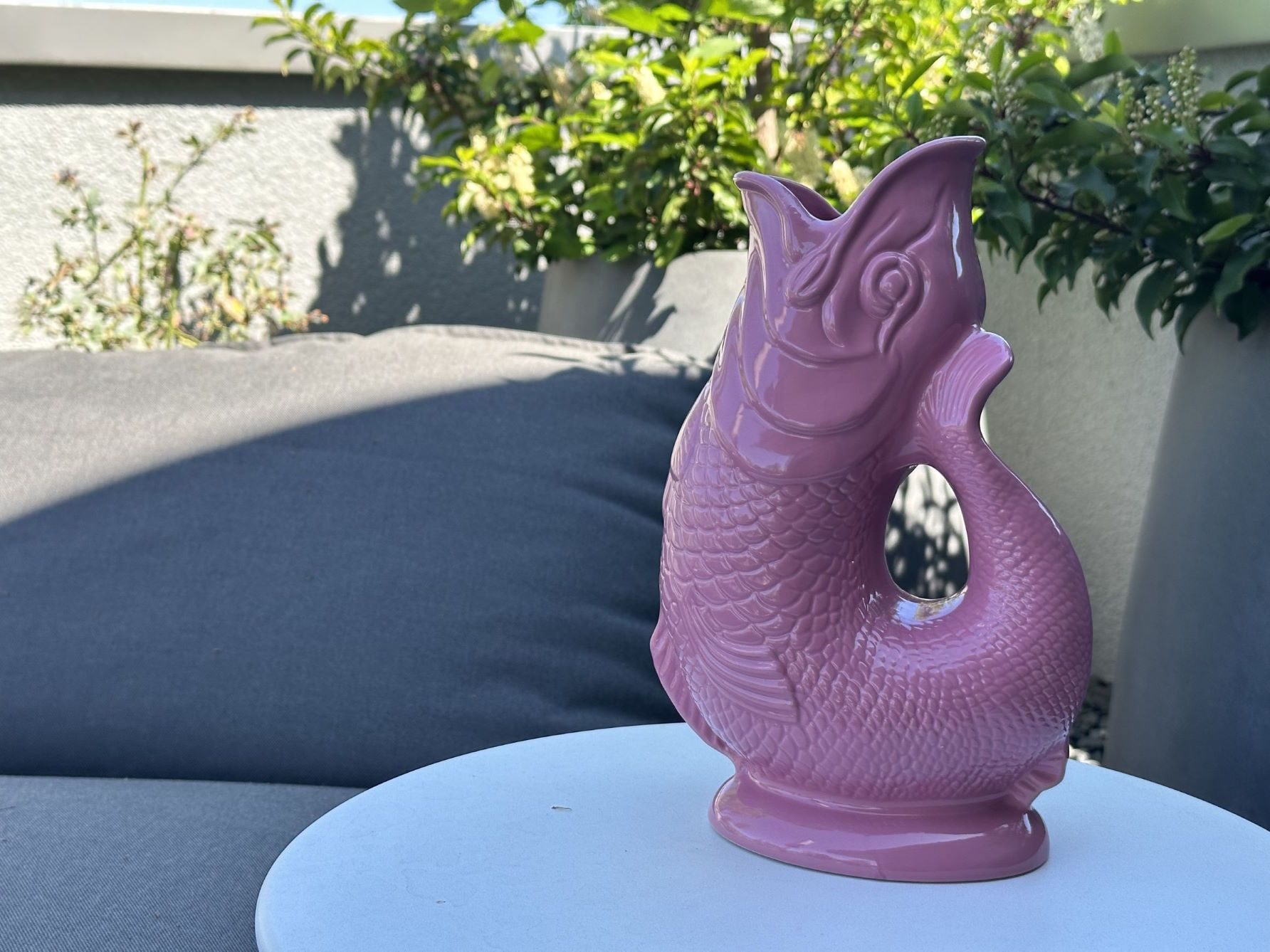 Rosa Gluckigluck Fischkaraffe XL auf einem Tisch im Freien. Dekorative Keramik Vase.