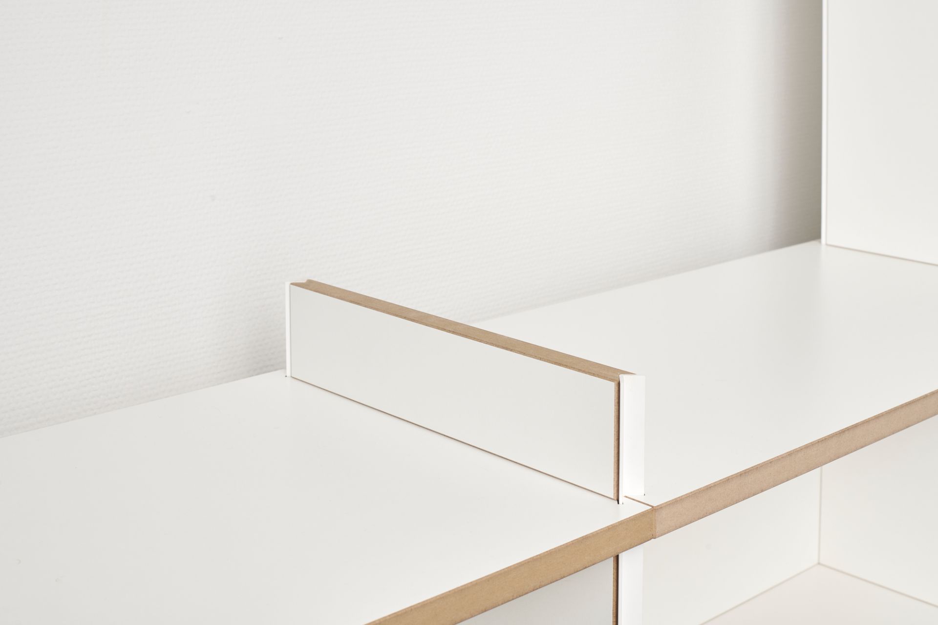Detailaufnahme: Weißes Tojo Regal Anbaumodul, Mehrfachregal aus Holz, modernes Regalsystem für Wohnzimmer und Büro.