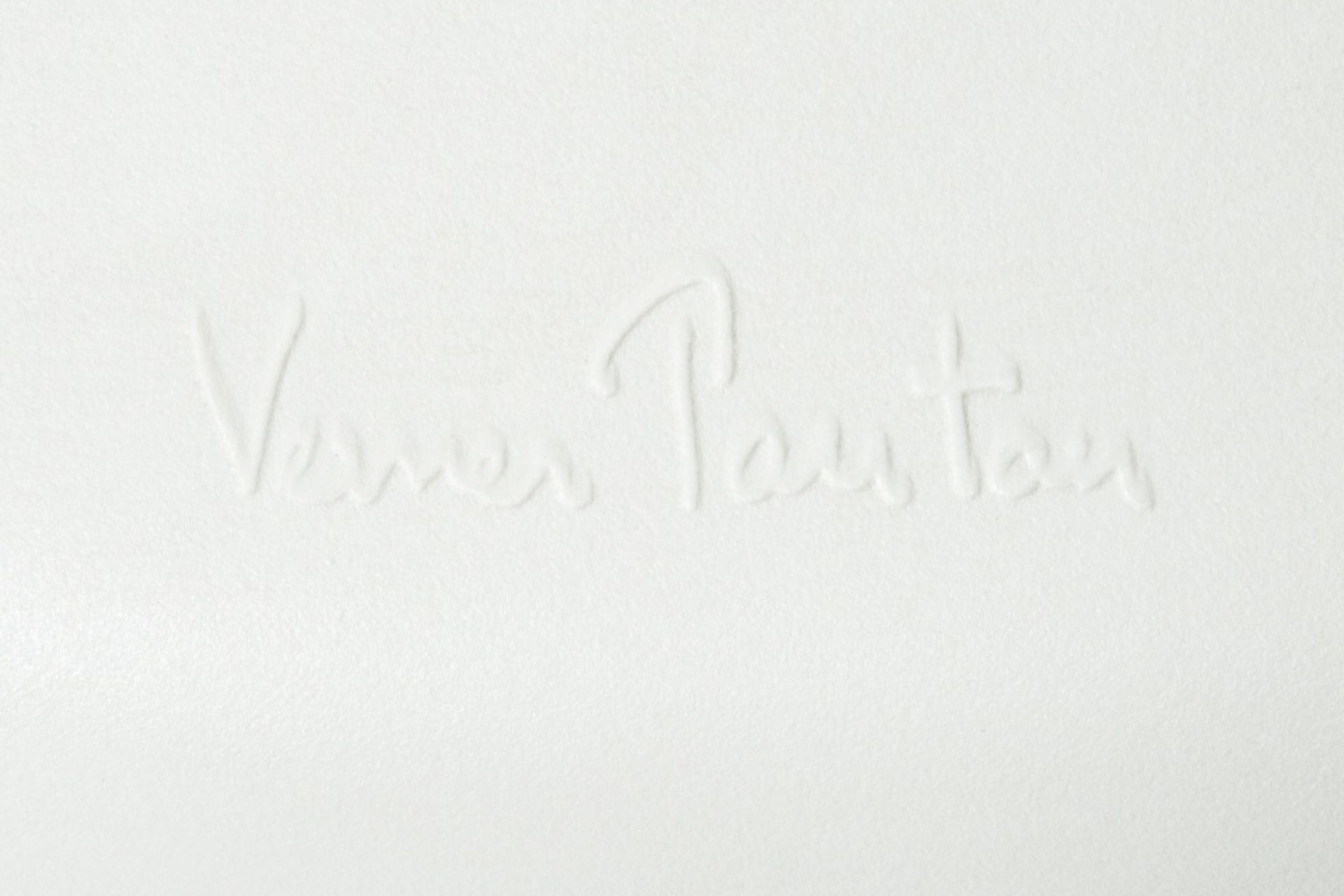 Detailaufnahme der Signatur "Verner Panton" auf einem weißen Panton Chair Kunststoffstuhl.