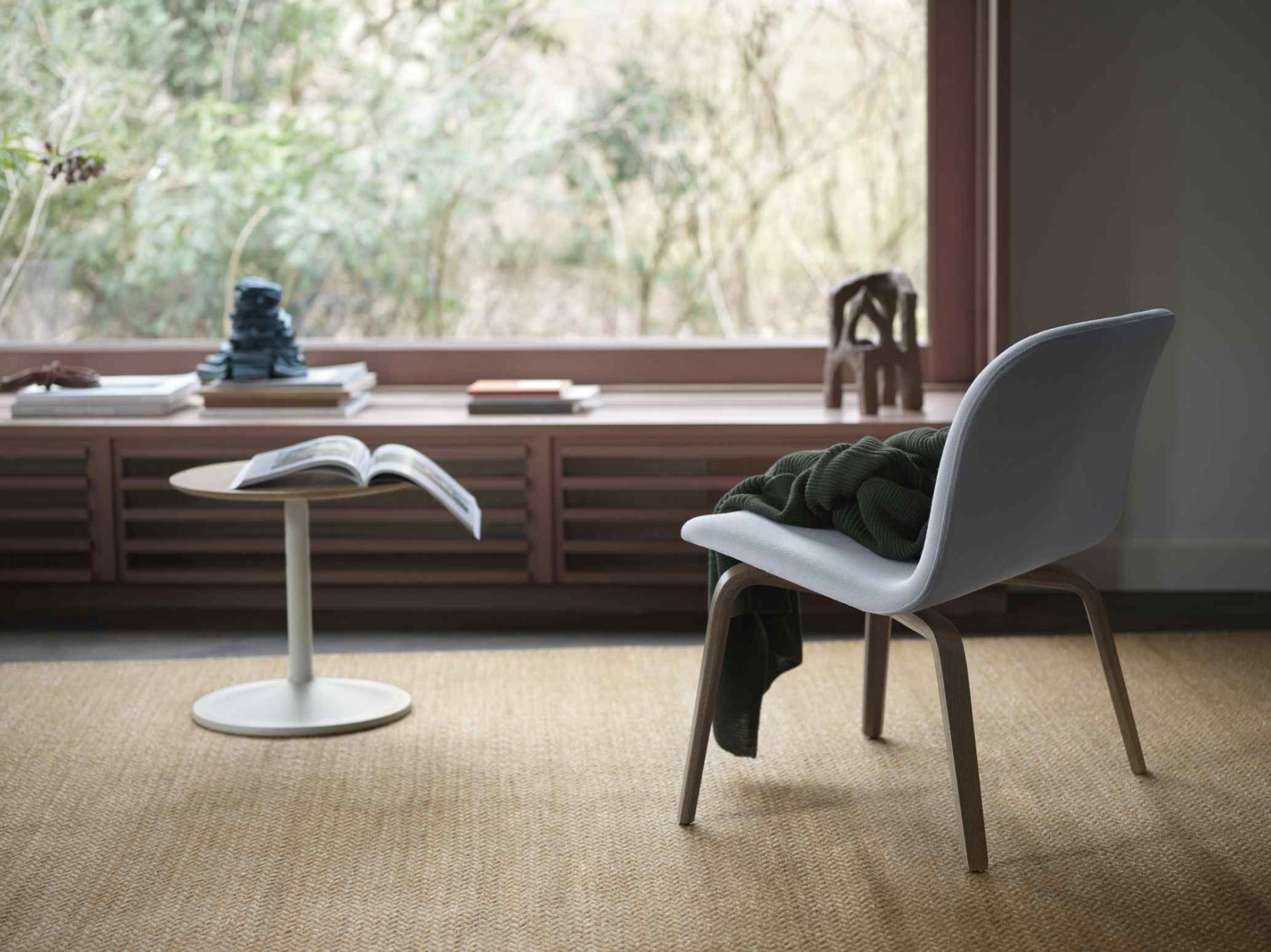 Nahaufnahme des Muuto Soft Side Table Beistelltisches mit Buch und Stuhl in wohnlicher Atmosphäre.