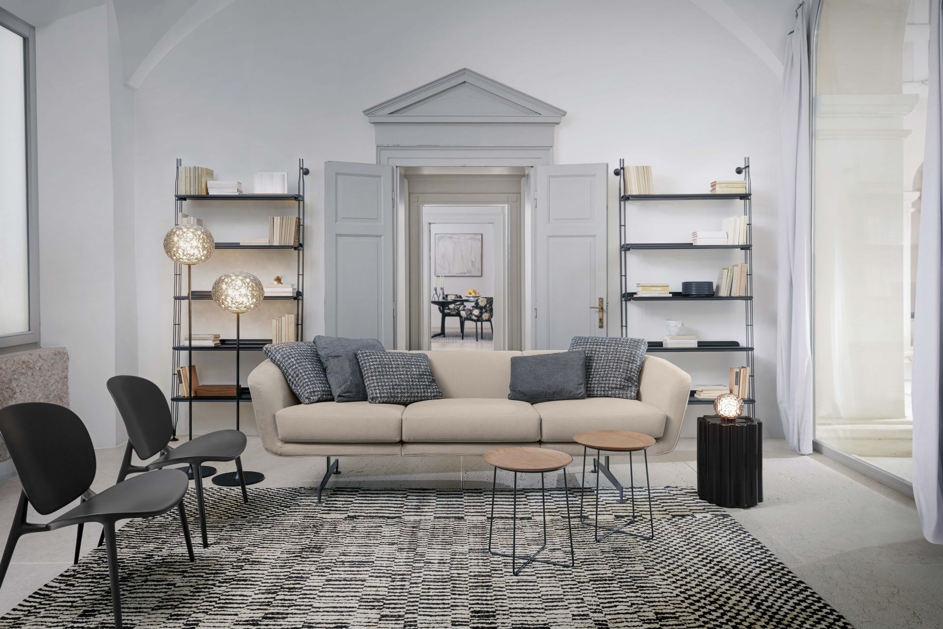 Wohnzimmer mit Adam Wood Regal von Kartell, Sofa, Teppich und Designermöbeln.