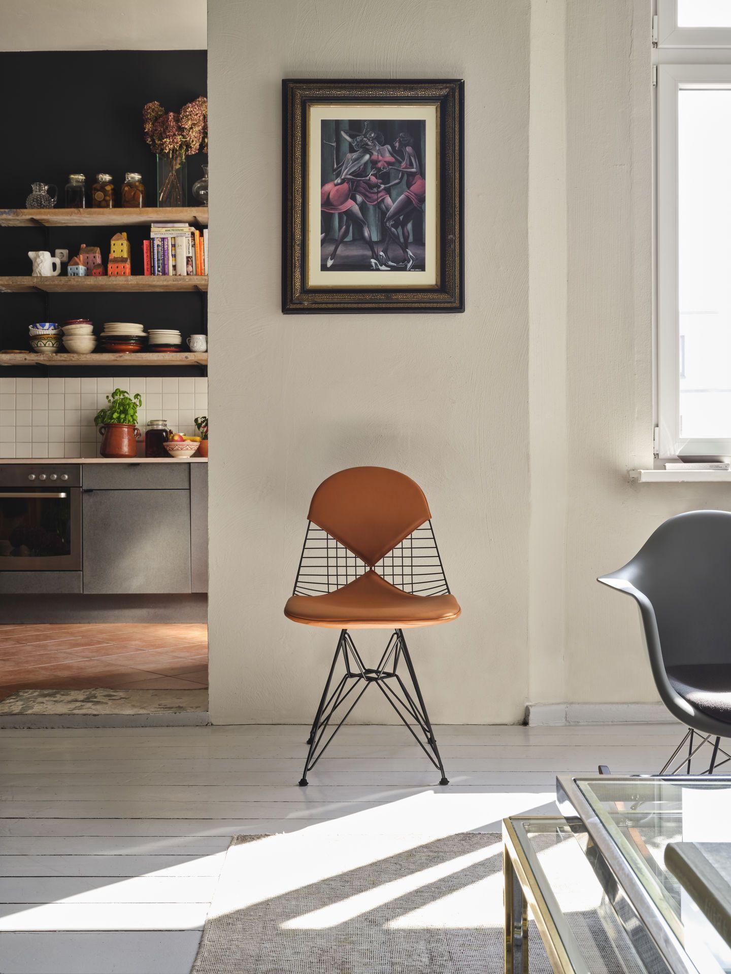Vitra DKR-2 Wire Chair Stuhl mit braunem Sitzpolster und schwarzem Drahtgestell in modernem Wohnraum.