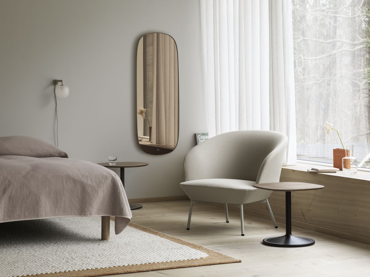 Beiger Oslo Lounge Chair Sessel von Muuto in einem hellen, modern eingerichteten Schlafzimmer.