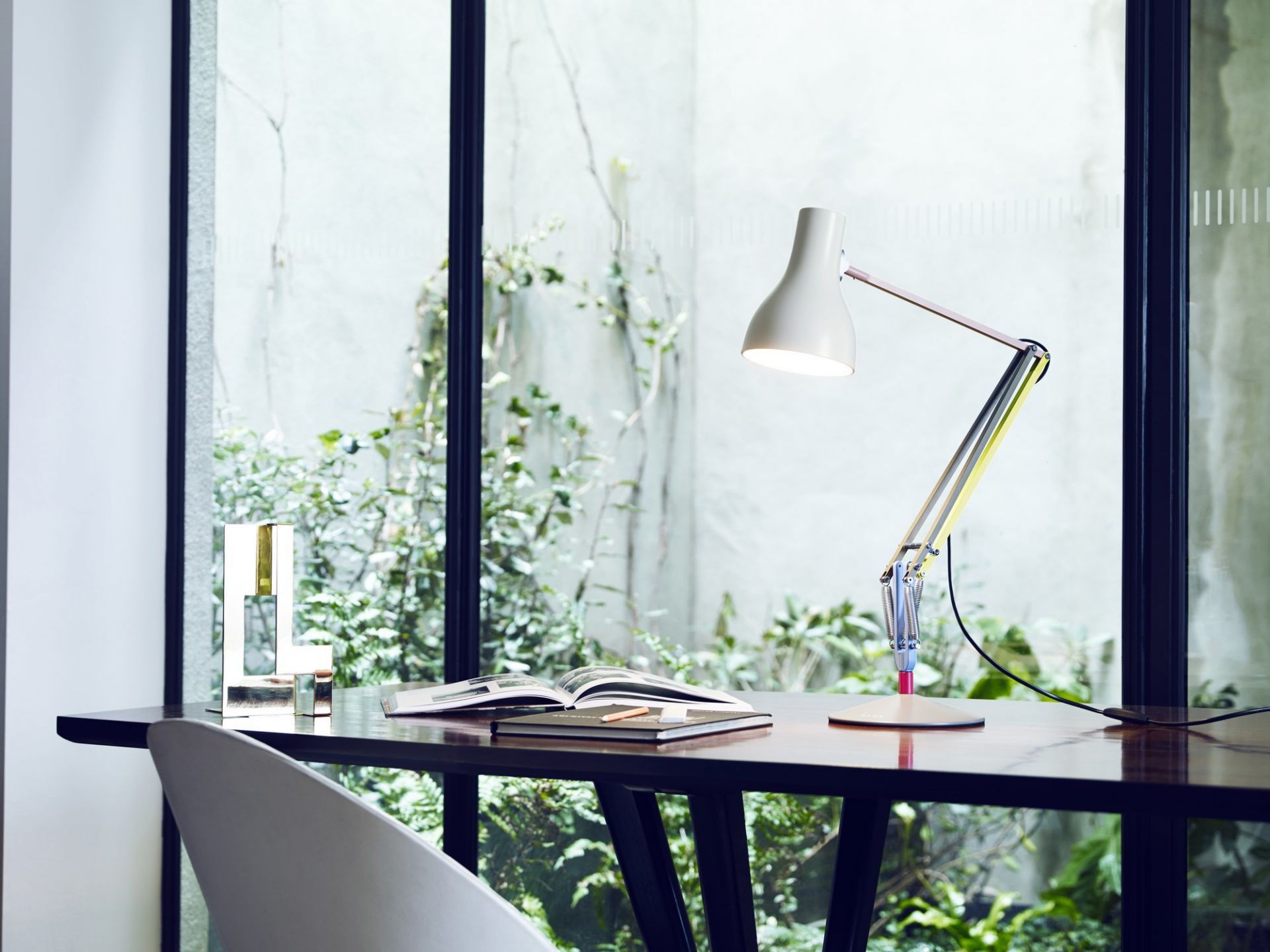Anglepoise Type 75 Paul Smith Edition Tischleuchte in Weiß auf Schreibtisch vor Fenster mit Gartenblick.