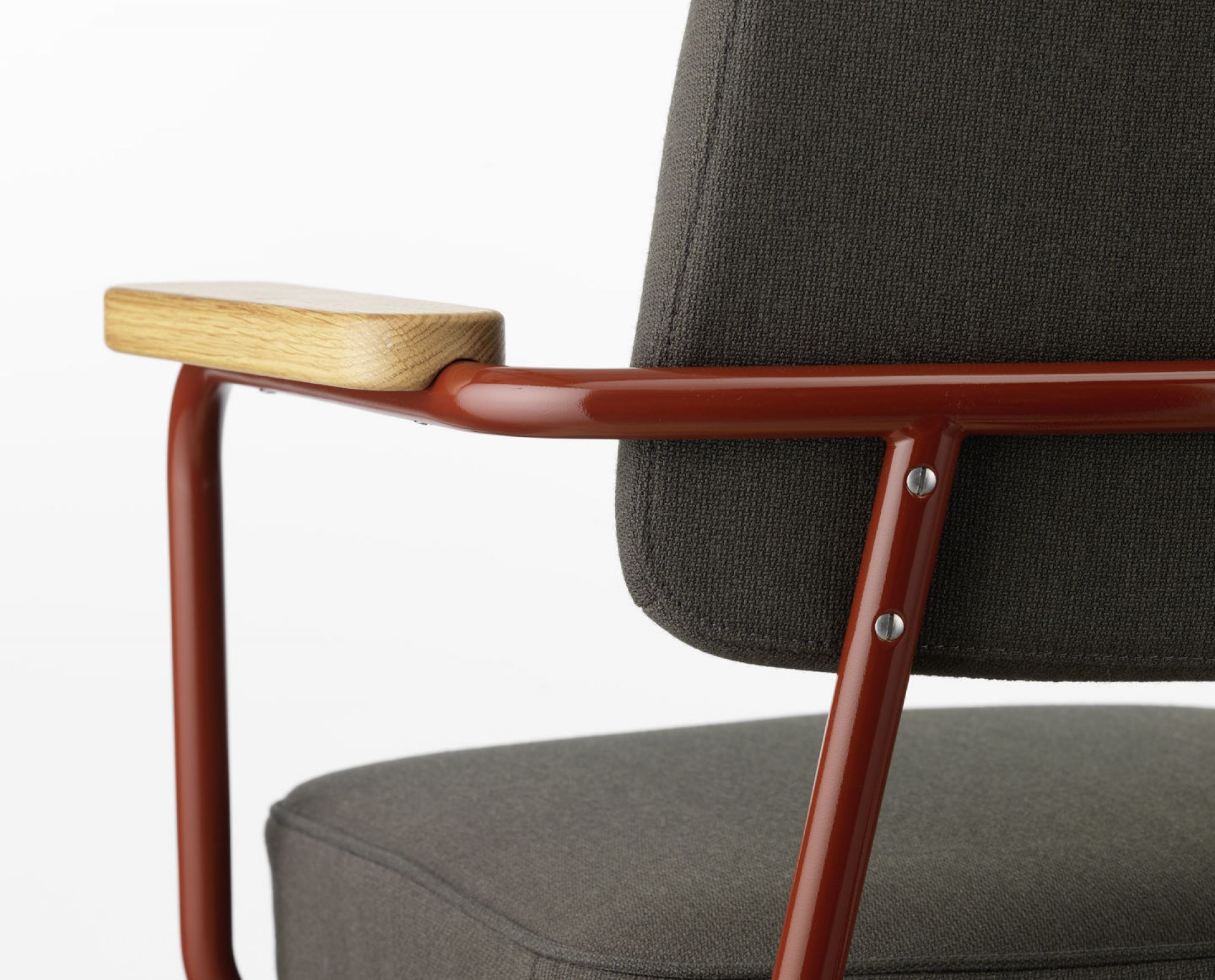 Detailaufnahme des Vitra Fauteuil Direction Pivotant Bürodrehstuhls mit braunem Gestell, Holzarmlehne und grauem Stoffbezug.