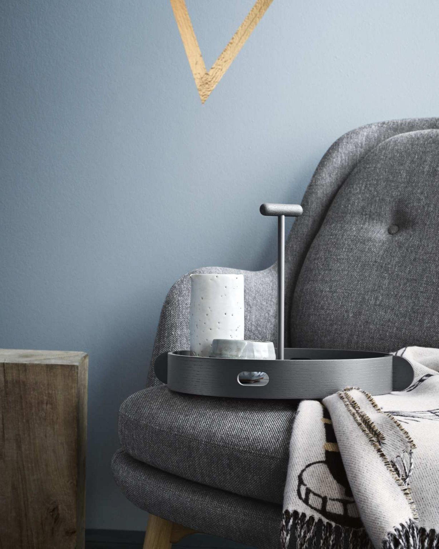 Grauer Fri Sessel von Fritz Hansen mit Tablett, Tasse und Decke im modernen Wohnzimmer.