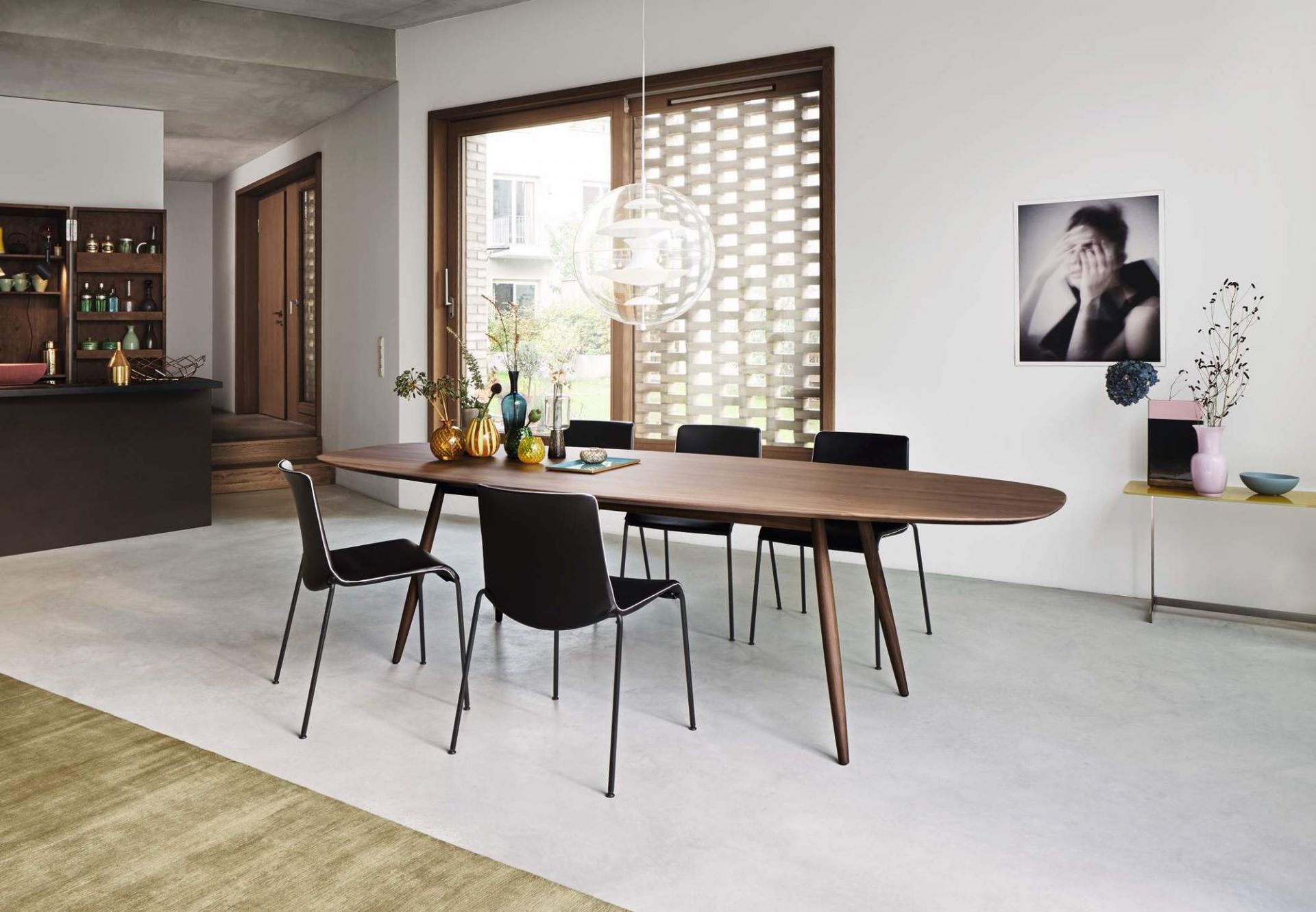 Esszimmer mit ovalem Holztisch und schwarzen Liz Stühlen von Walter Koll, modernes Möbeldesign.