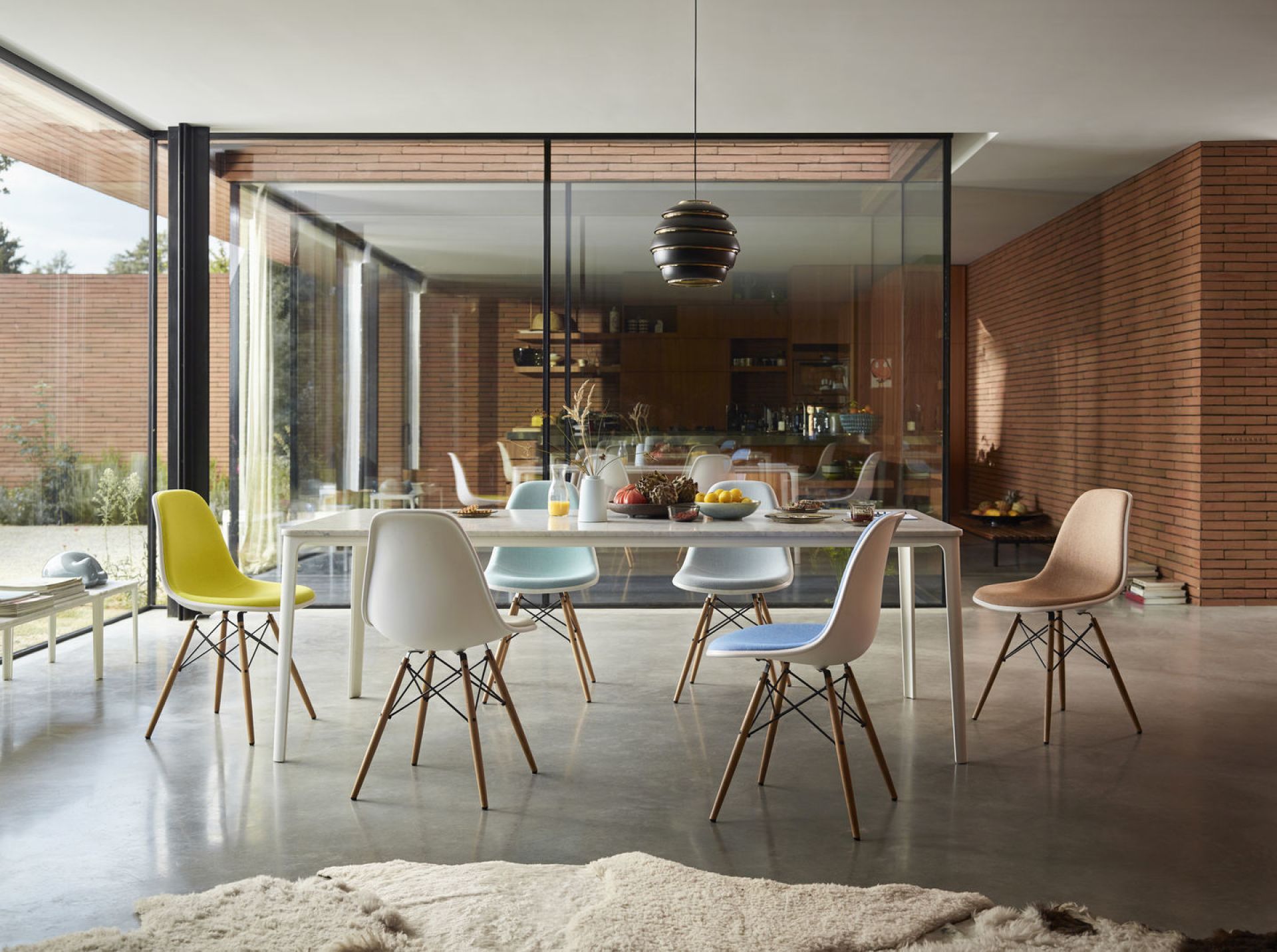 Esszimmer mit Eames Plastic Side Chairs DSW von Vitra in verschiedenen Farben und Sitzpolstern.