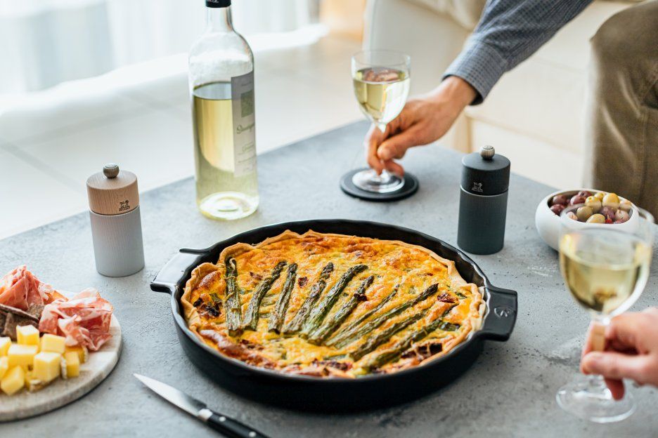 Produktfoto: Peugeot Line Pfeffermühle H 12 cm Graphit & Carbon neben Quiche, Wein und Antipasti.