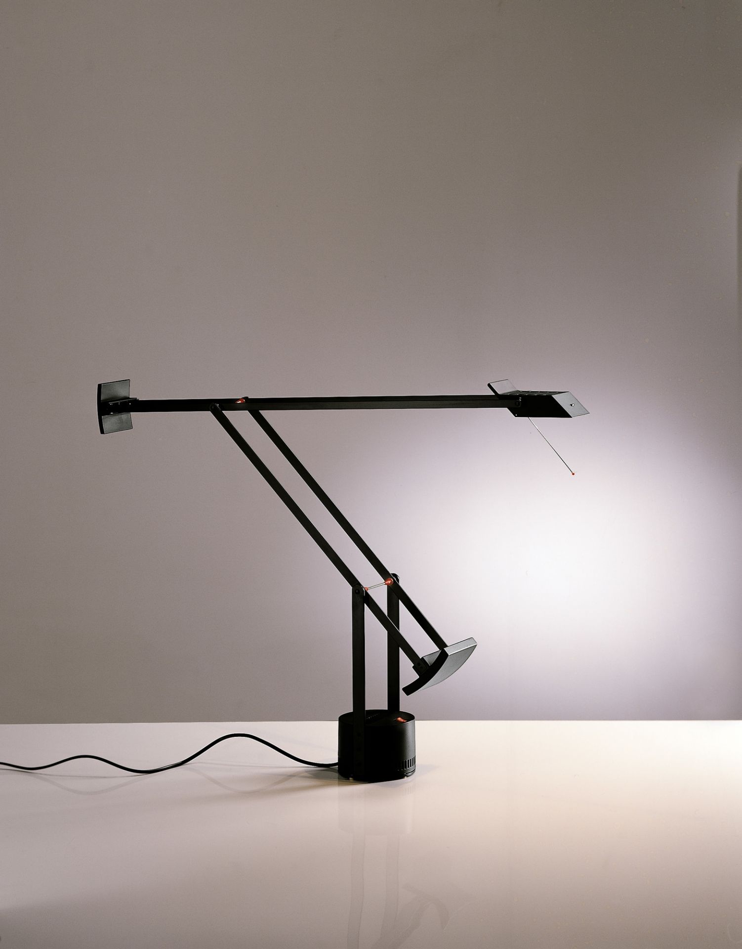 Schwarze Tizio Tischleuchte von Artemide, moderne Schreibtischlampe mit verstellbarem Arm und hellem Lichtschein.
