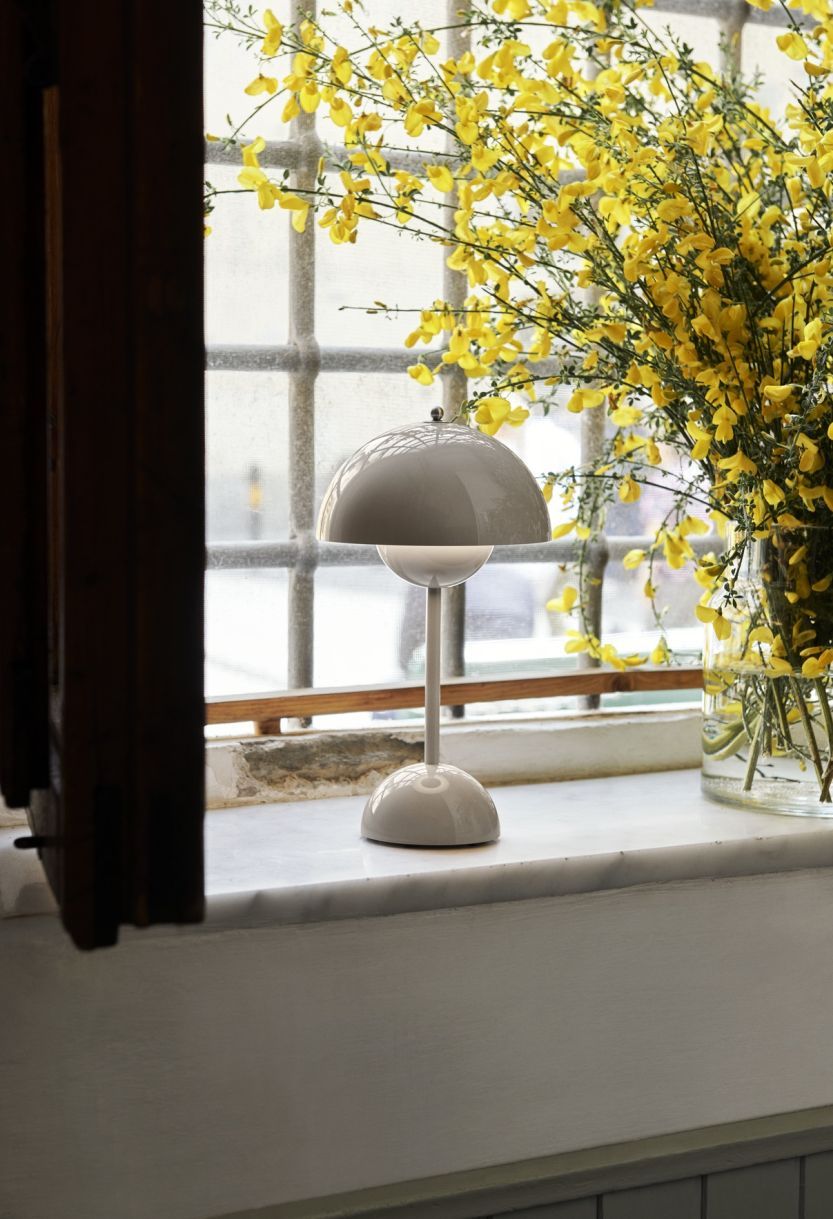 Flowerpot VP9 Tischleuchte in Grau Beige von AndTradition auf einer Fensterbank.