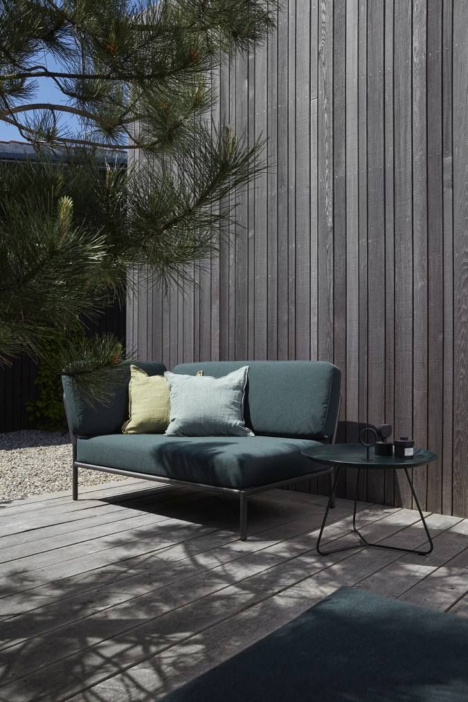 Houe Level Outdoor Sofa Ecke links, modernes Gartensofa mit Kissen und Beistelltisch auf Holzterrasse.