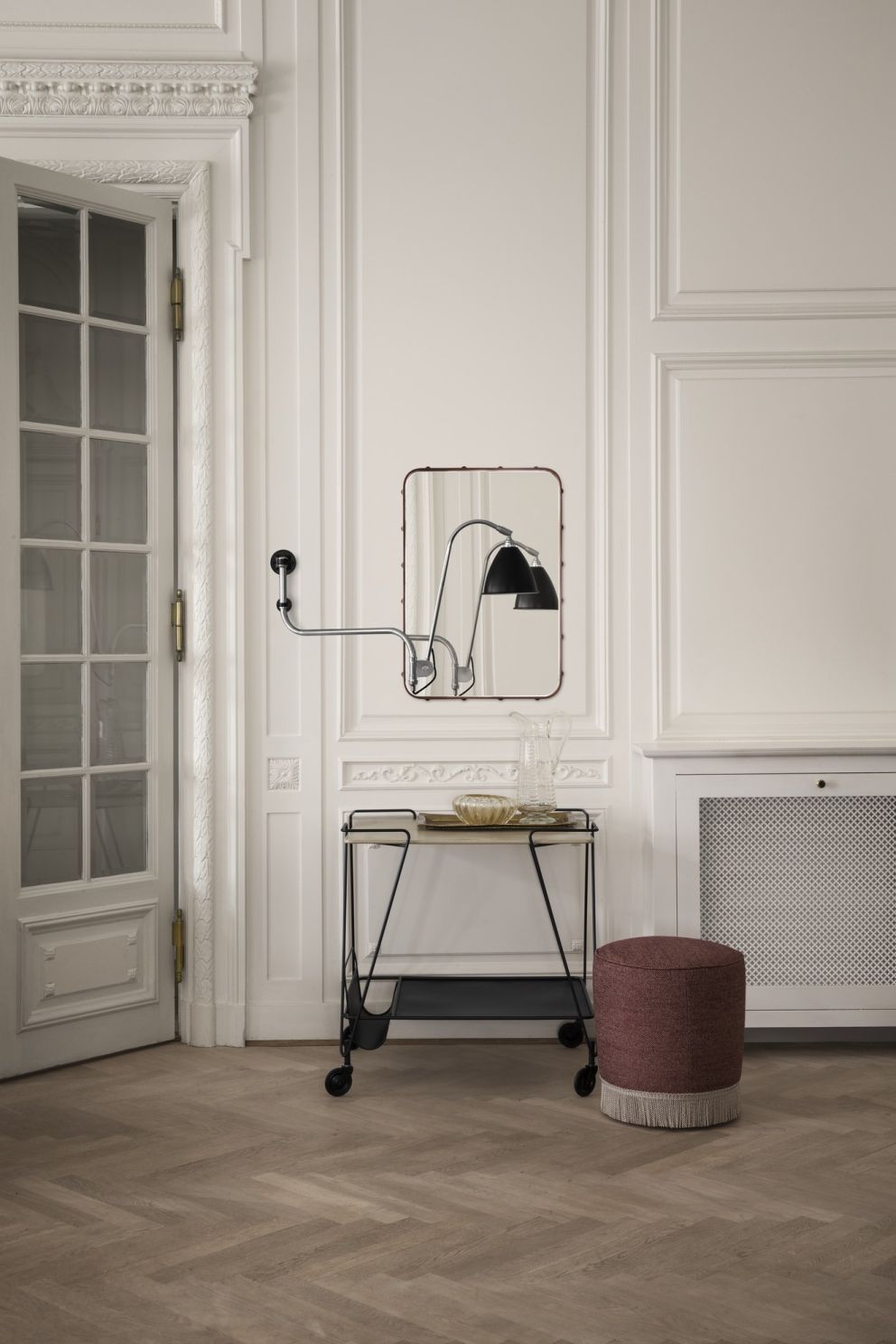 Adnet Rectangular Spiegel von Gubi in einem eleganten Interieur mit Servierwagen und Hocker.