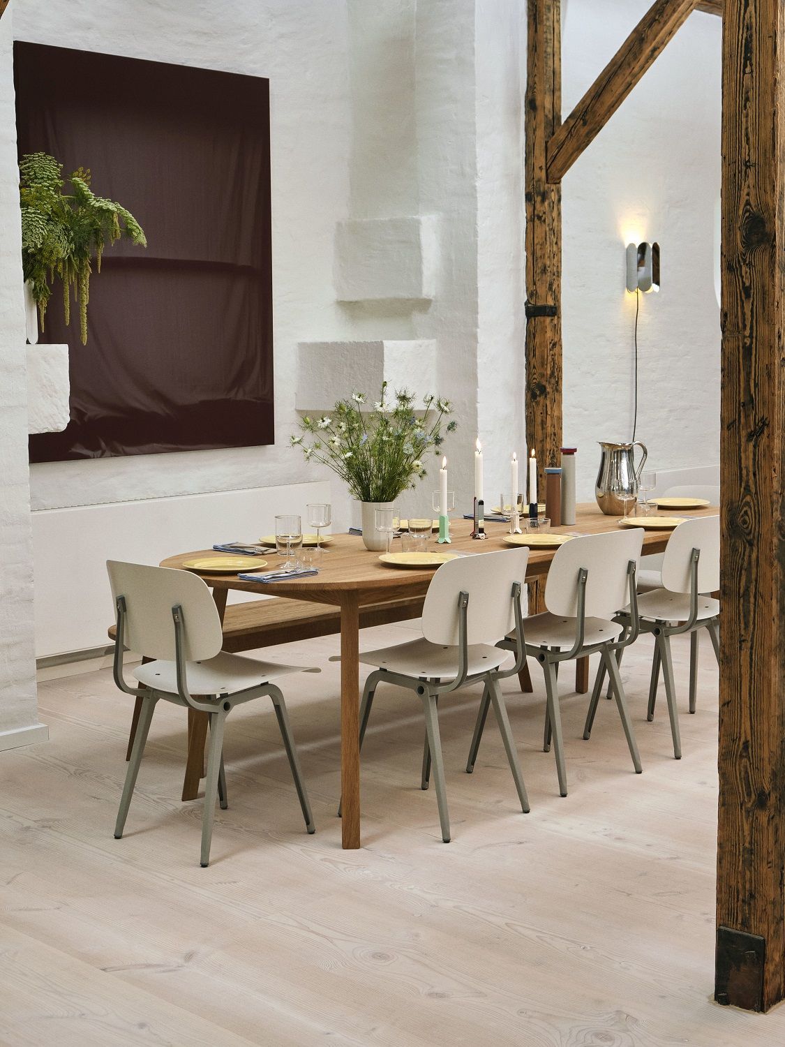 Heller Essbereich mit ovalem Triangle Leg Table von Hay, umgeben von Stühlen und rustikalen Holzbalken.