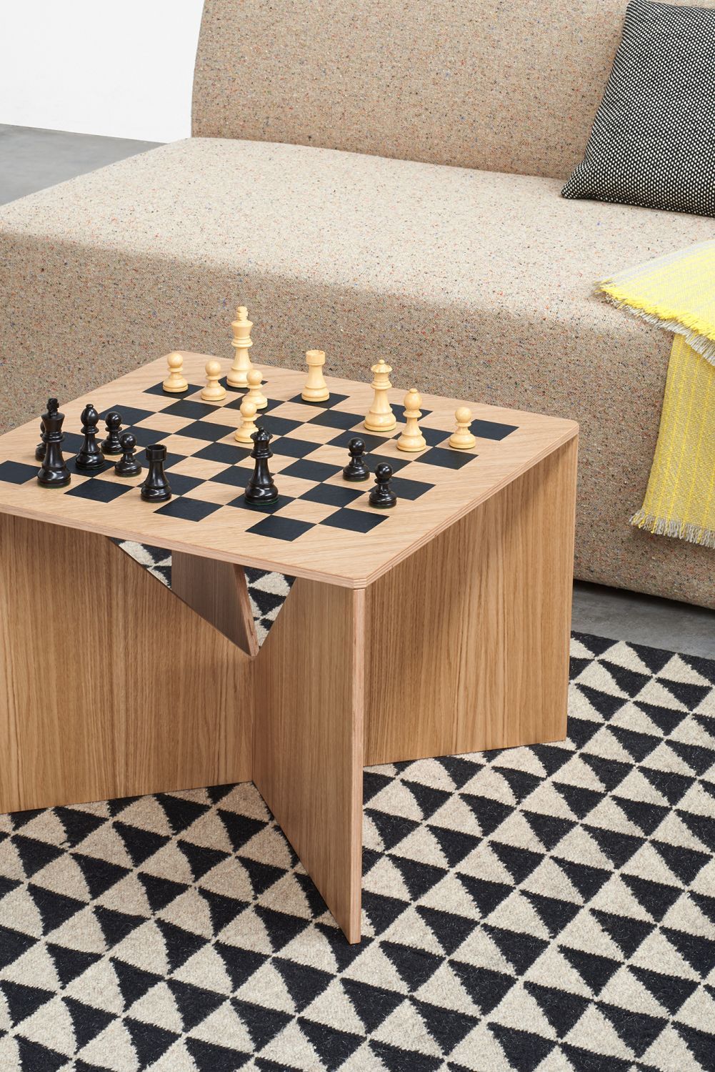 FK04 Calvert Couchtisch aus Eiche von e15 mit Schachbrettmuster und Schachfiguren.