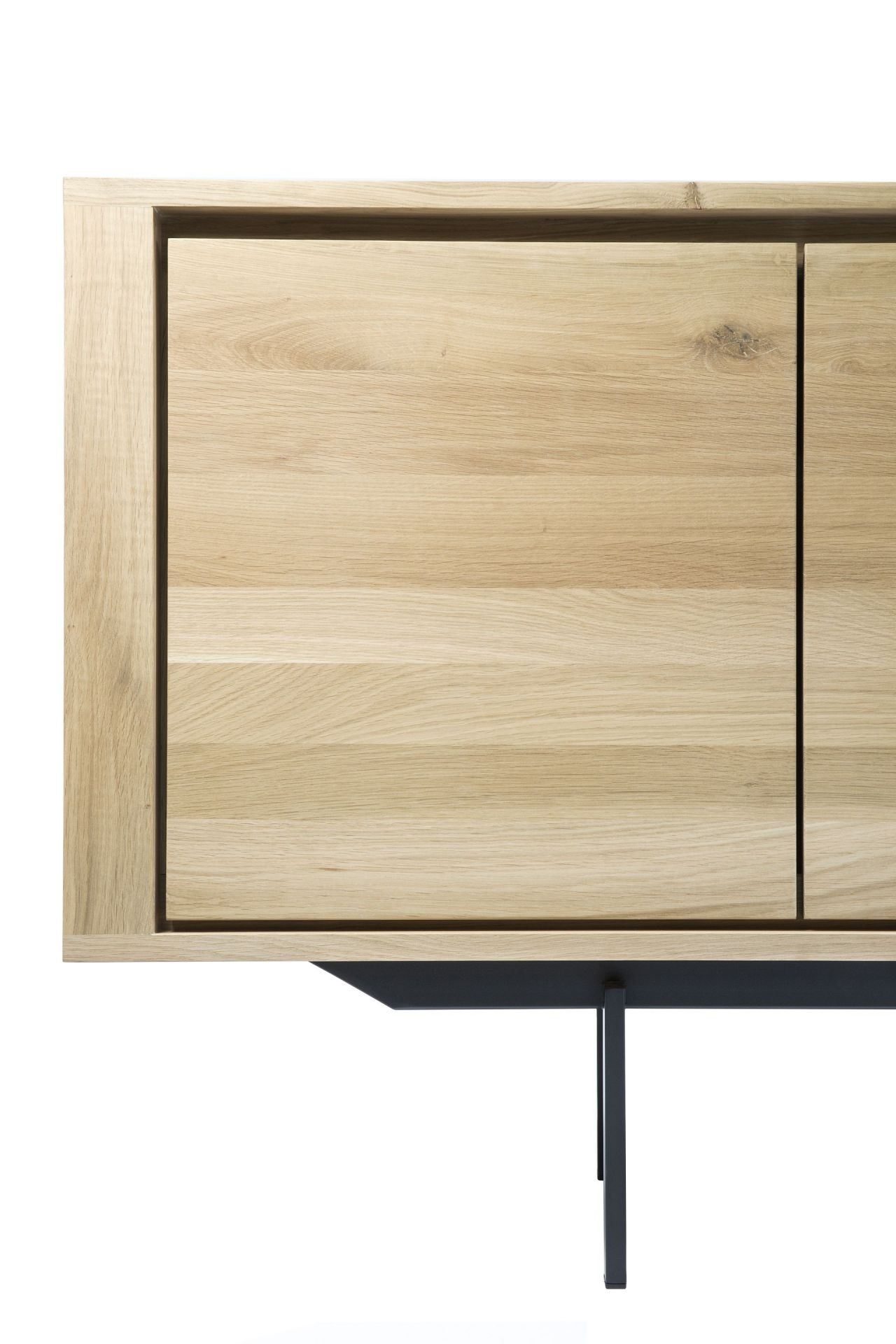 Detailaufnahme der Ethnicraft Shadow Eiche Anrichte: Modernes Sideboard aus hellem Eichenholz mit schwarzen Metallbeinen.