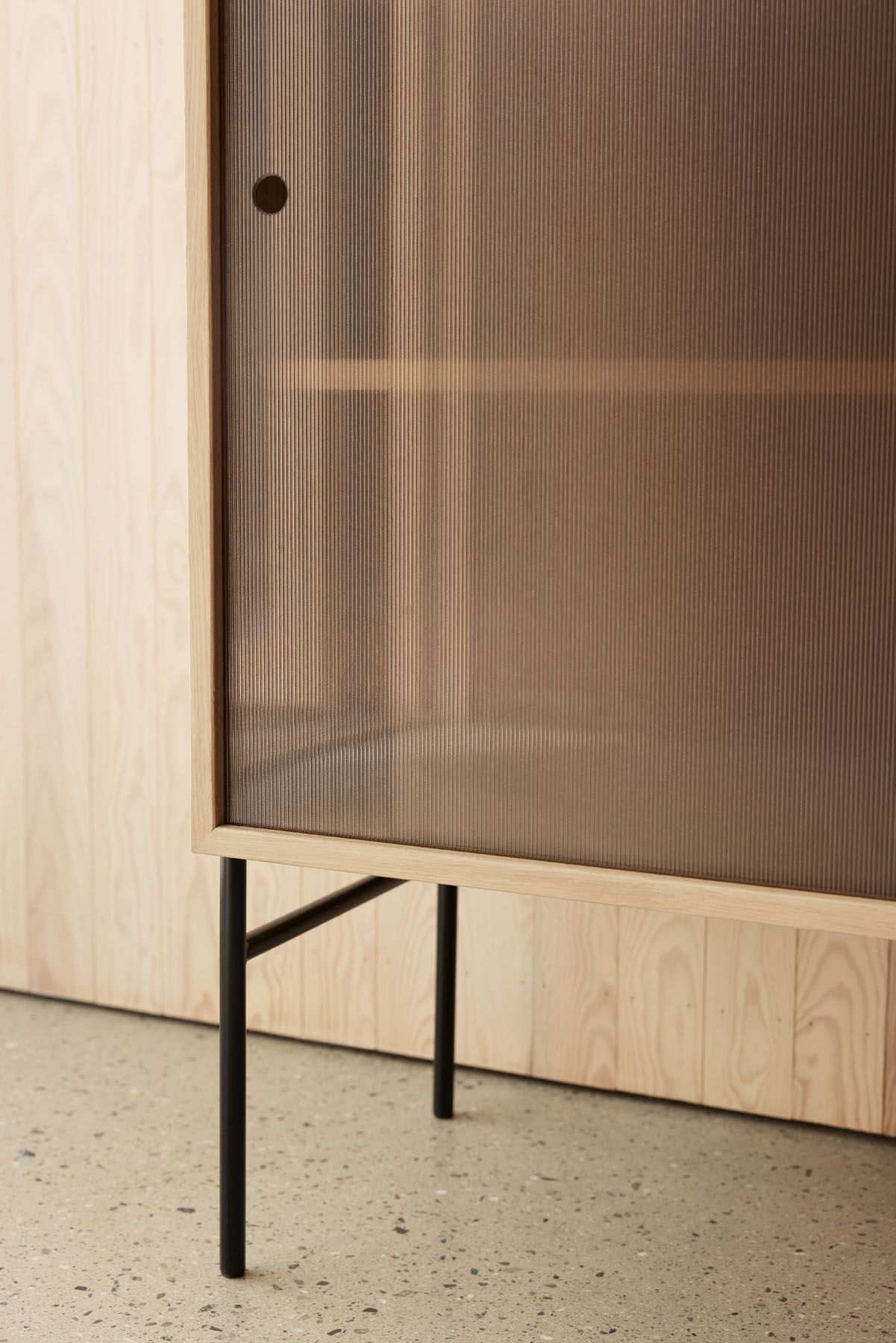 Detailaufnahme der Hifive Glasvitrine mit Eichenrahmen und schwarzen Beinen. Moderne Vitrine für Wohnzimmer.