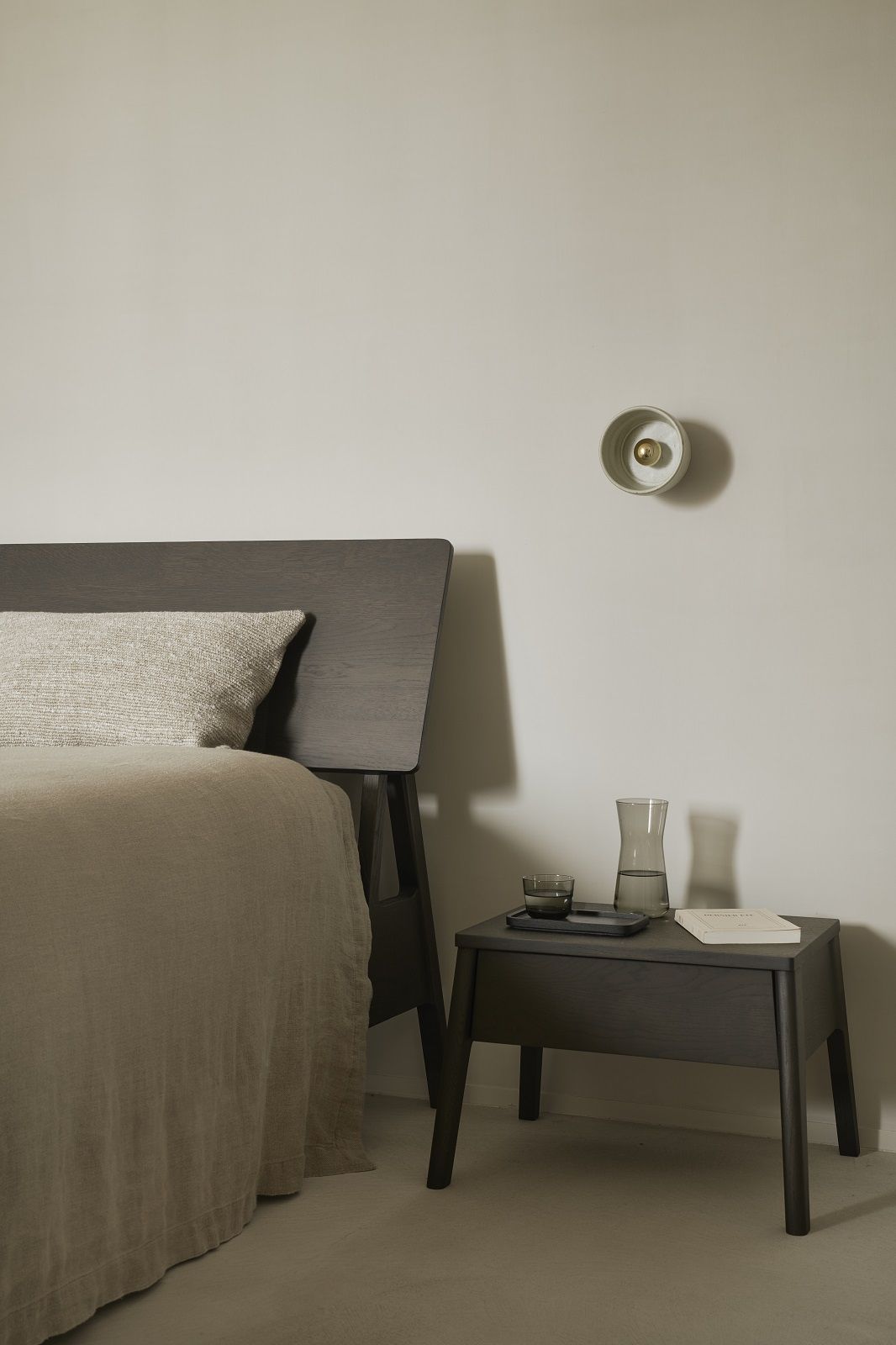 Air Bett Eiche braun von Ethnicraft mit Nachttisch und Lampe im Schlafzimmer.