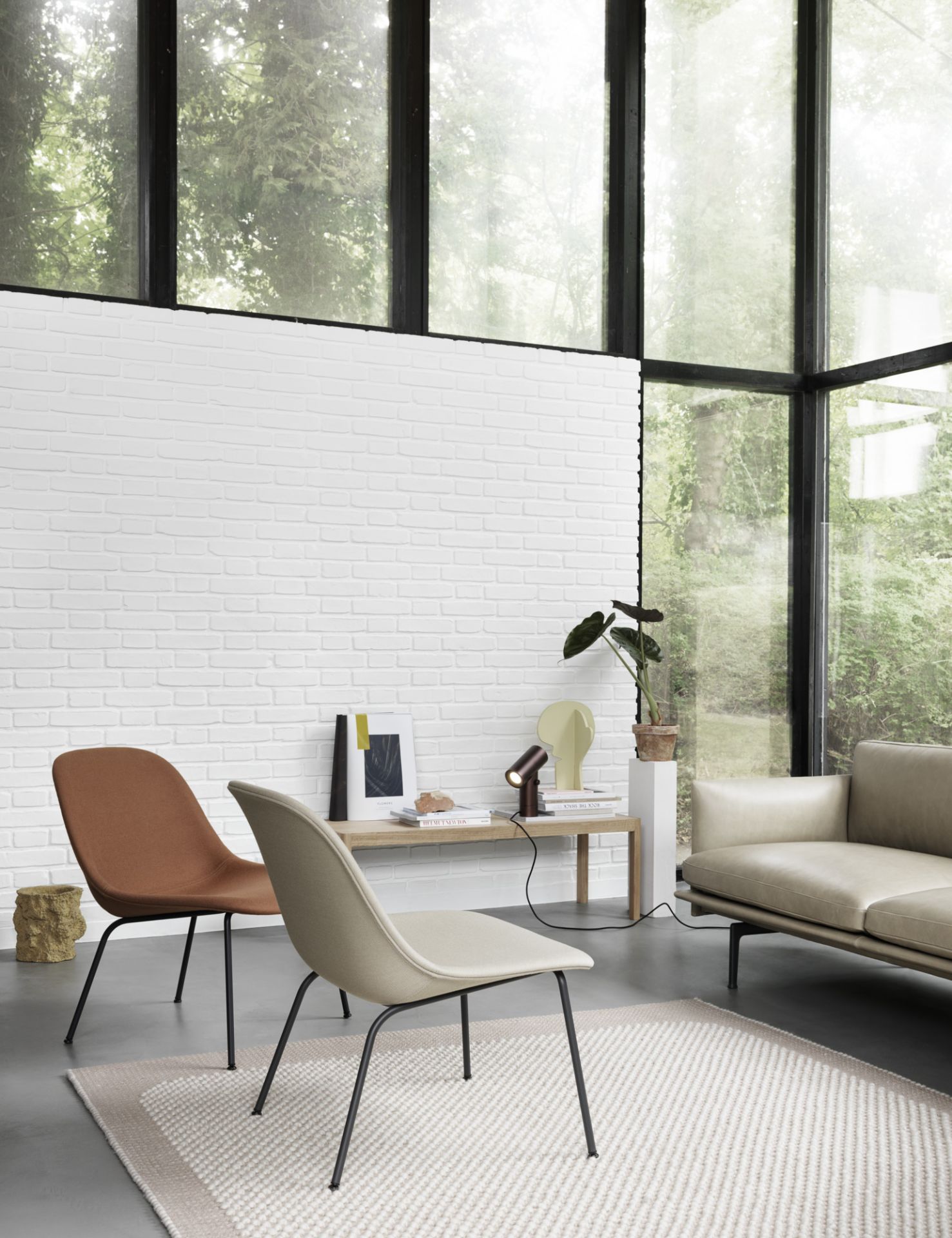 Moderne Wohnzimmer-Szene mit Muuto Beam Lamp Tischleuchte aus Aluminium auf einem Holztisch.