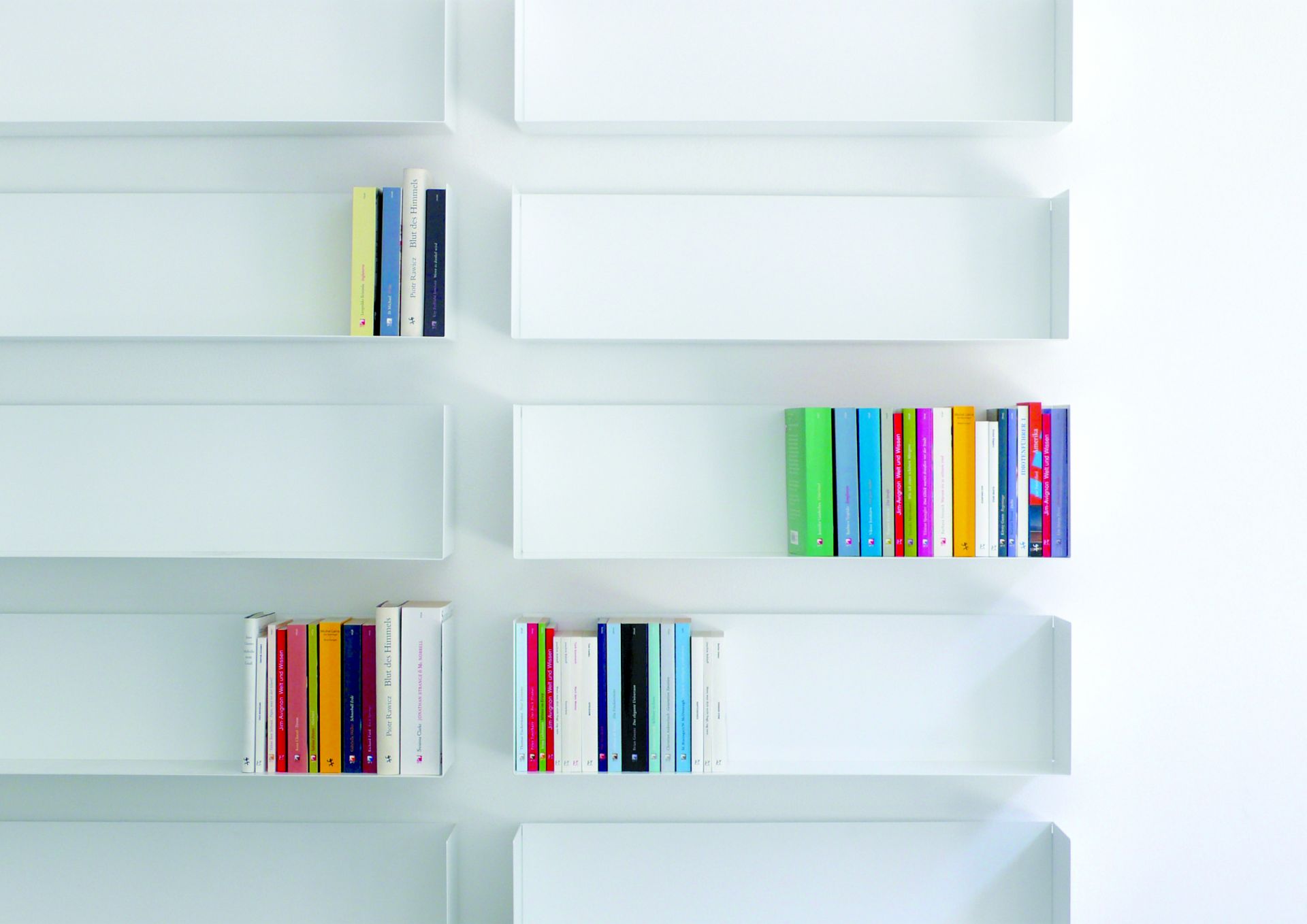 Weißes Taschenbuchregal a Linea1 von Müller Möbelwerkstätten mit Büchern an einer weißen Wand.