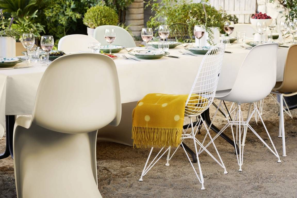 Beiger Panton Chair Kunststoff Stuhl von Vitra an gedeckter Tafel im Garten. Designklassiker.