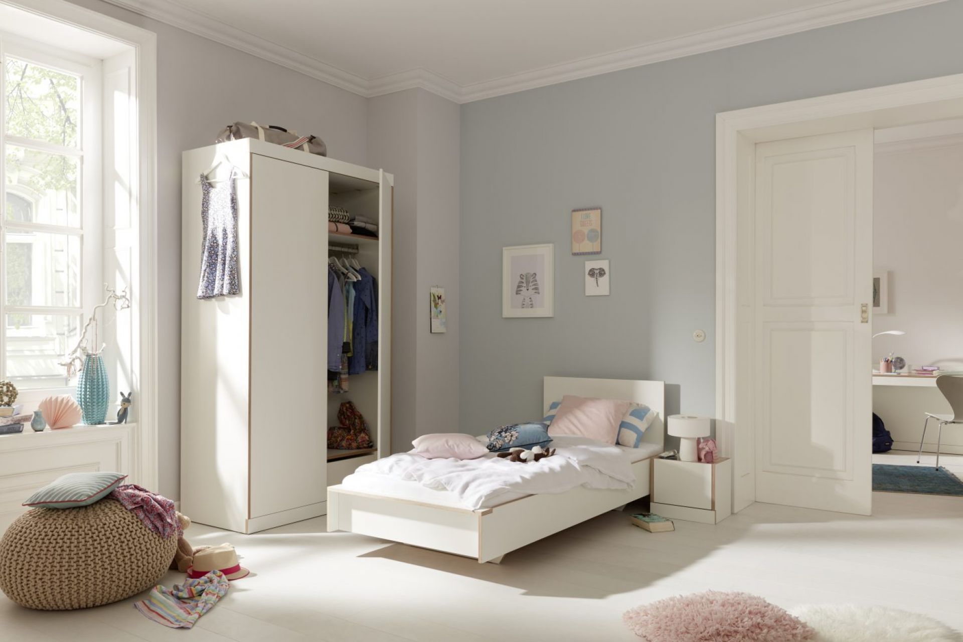 Helles Kinderzimmer mit weißem Flai Bett von Müller Möbelwerkstätten, 140 cm breit, und Kleiderschrank.