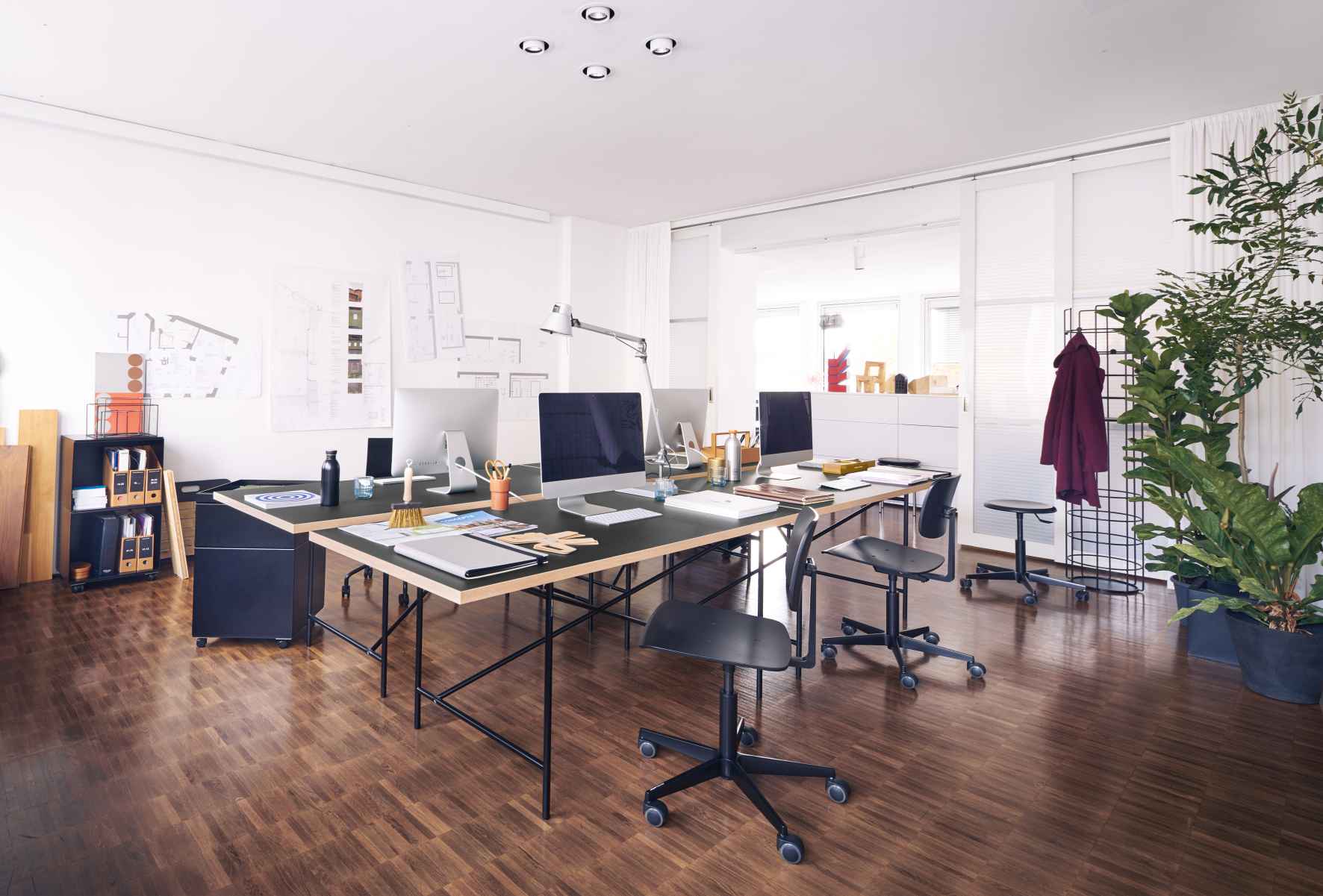 Büro mit mehreren Eiermann Tischen von Richard Lampert, Computern und Büromaterial für modernes Arbeiten.