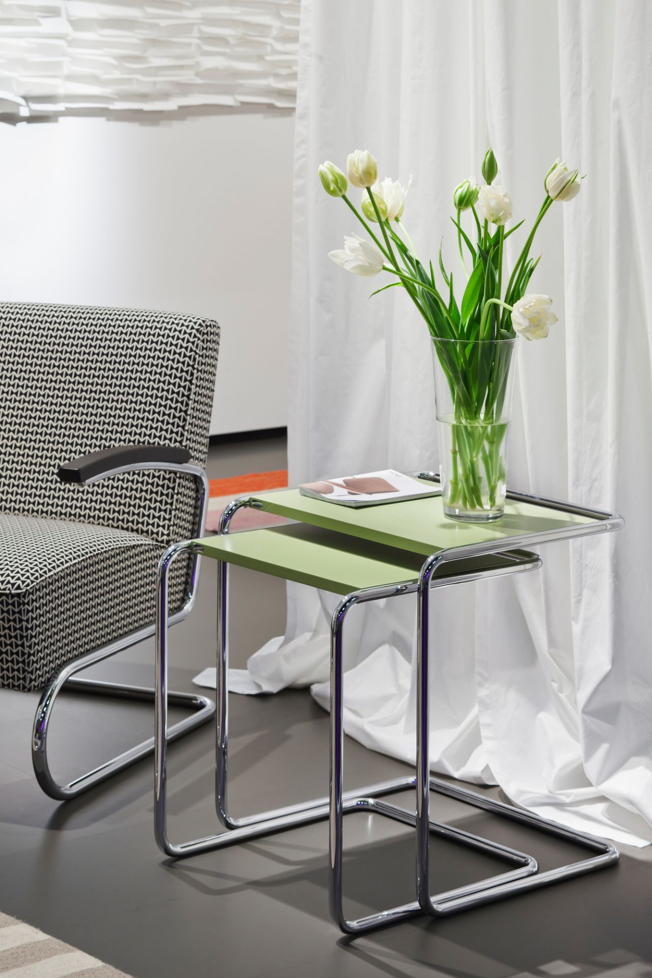 B97 Thonet Beistelltisch Set mit grünen Ablagen und Blumenstrauß im modernen Wohnzimmer.