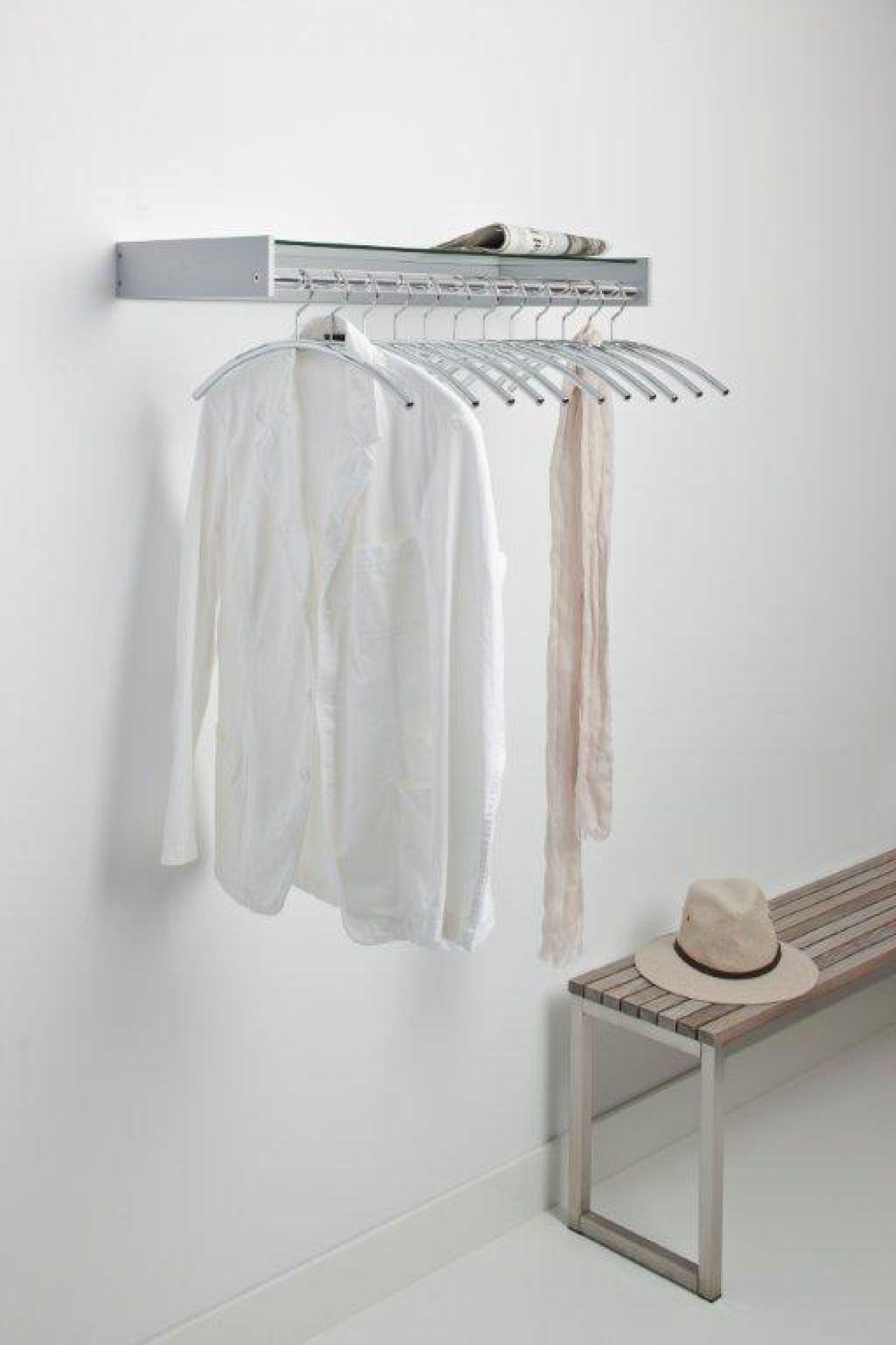 Hangon Wandgarderobe von Cascando mit Kleidung und Accessoires an silbernen Kleiderbügeln. Moderne Garderobenlösung.