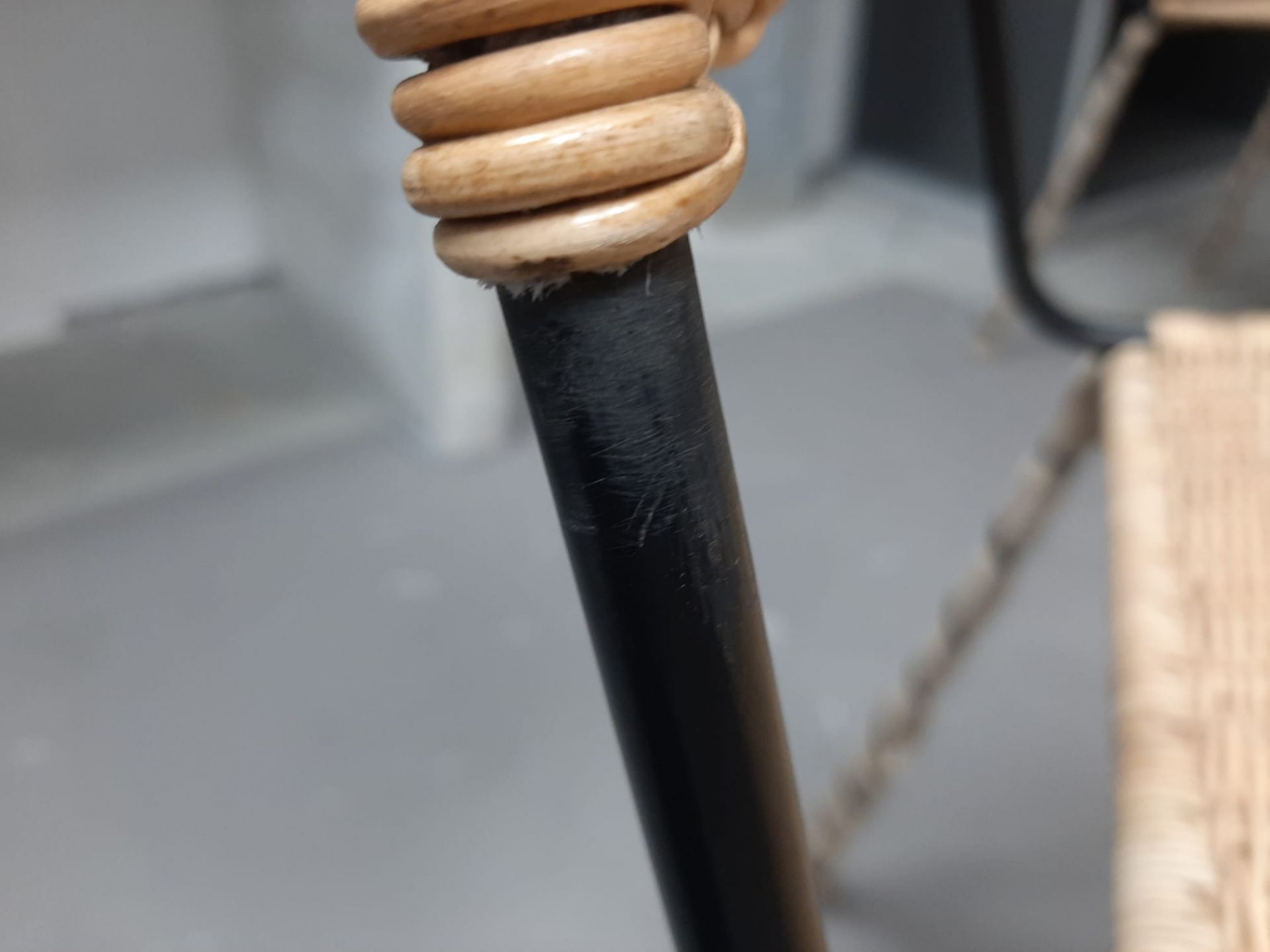 Detailaufnahme vom Stuhl TT 54 von Richard Lampert: Defekt am Holz und schwarzem Stuhlbein.