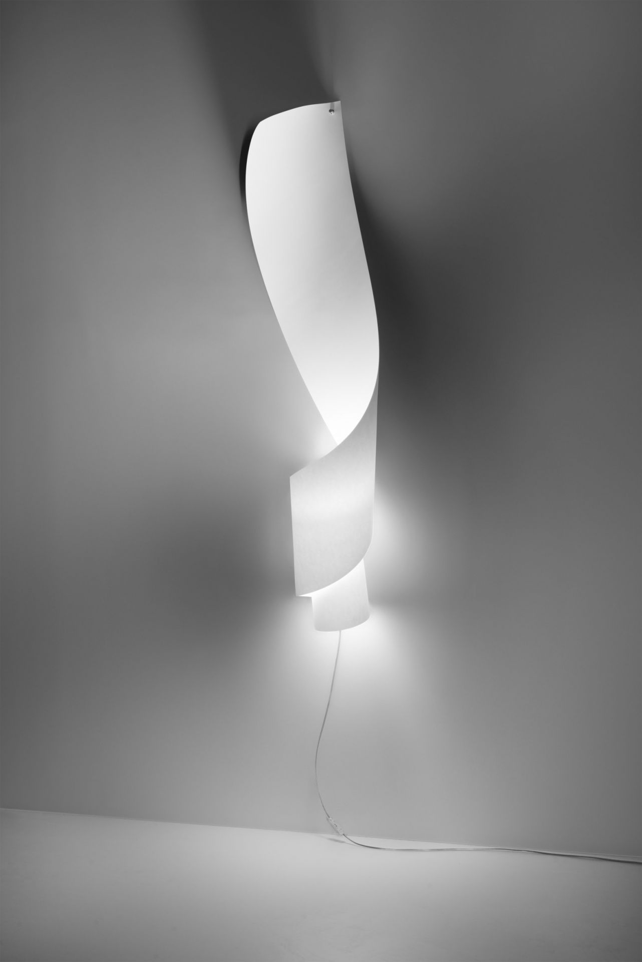 Weiße Oop´s Wandleuchte von Ingo Maurer, spiralförmiges Design, indirekte Beleuchtung, modernes Wohnaccessoire.