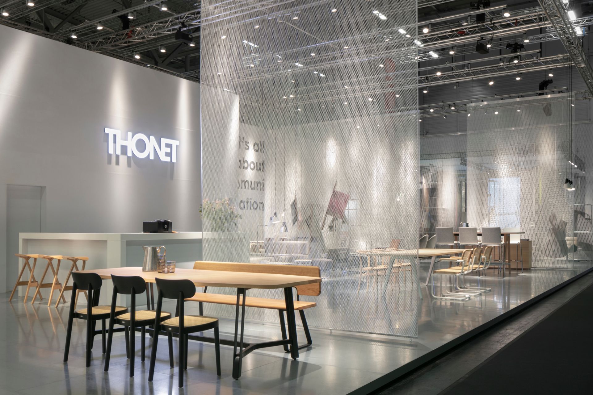 Ausstellungsstand mit Thonet Holzstuhl 118, Holztisch und Sitzbank in hellem, modernem Design.