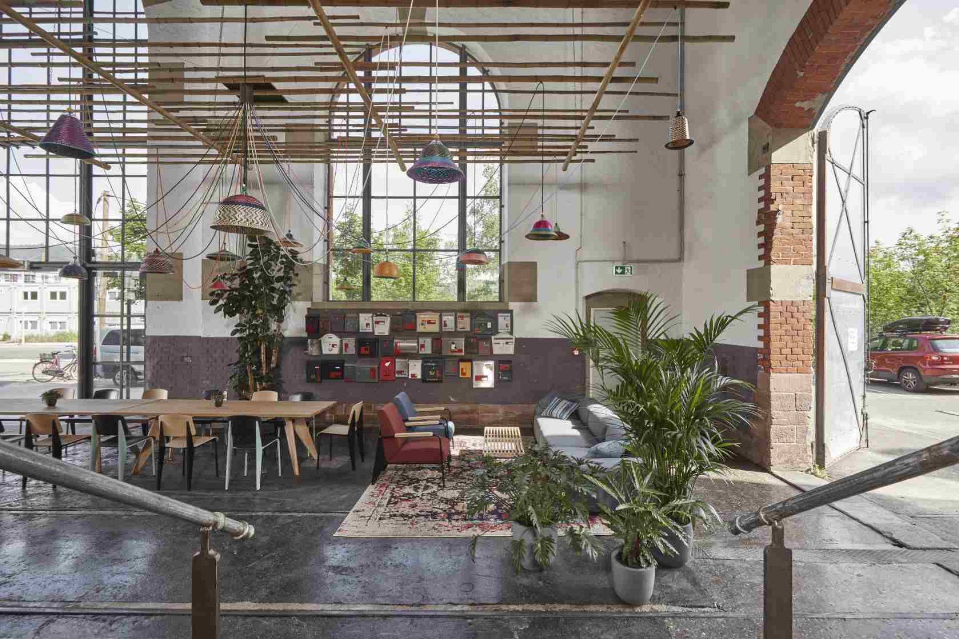 Innenaufnahme mit Vitra Table S.A.M Bois Tisch, langer Holztisch mit Stühlen in industriellem Ambiente.