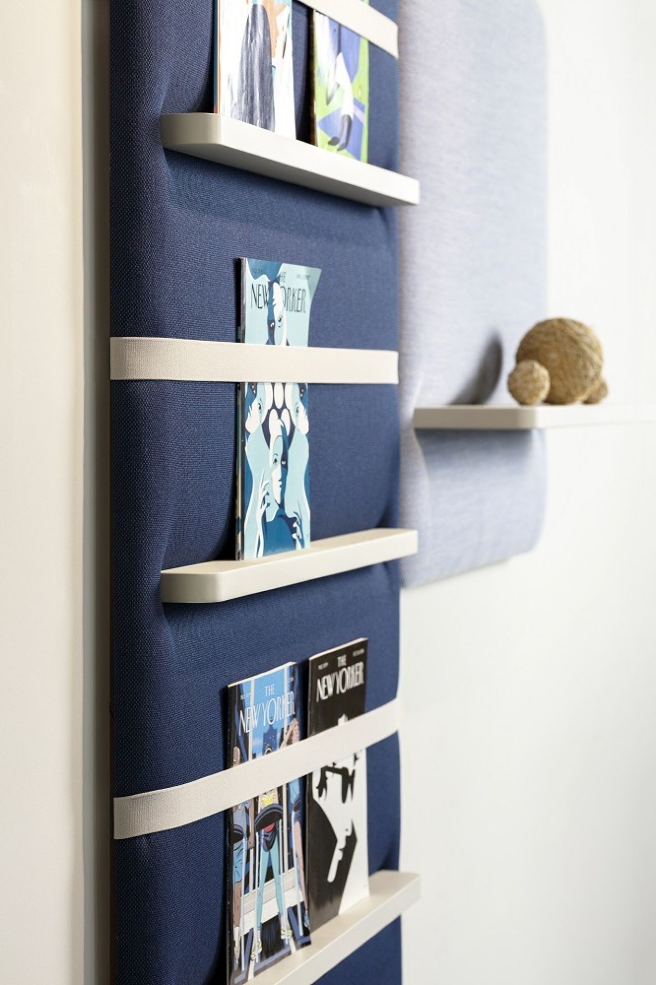 Cascando Pillow Wall Wandpaneel in Blau mit weißen Regalböden und Zeitschriften.