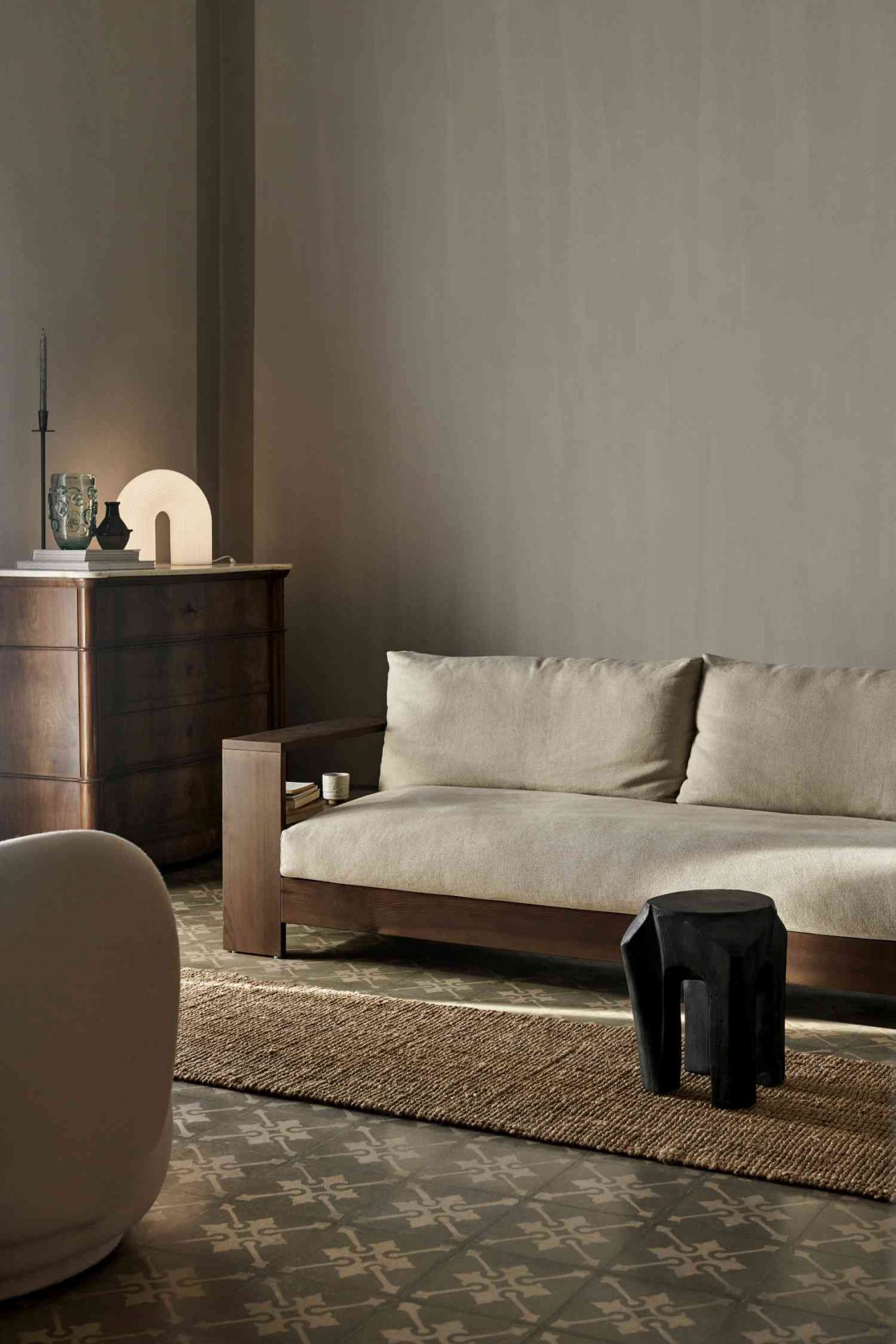 Nahaufnahme einer Vuelta Stehlampe von Ferm Living auf einer Holzkommode in einem Wohnzimmer.