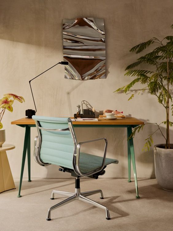 Vitra Aluminium Chair EA 132 in Hellblau vor Schreibtisch und Zimmerpflanze, Bürostuhl Designklassiker.