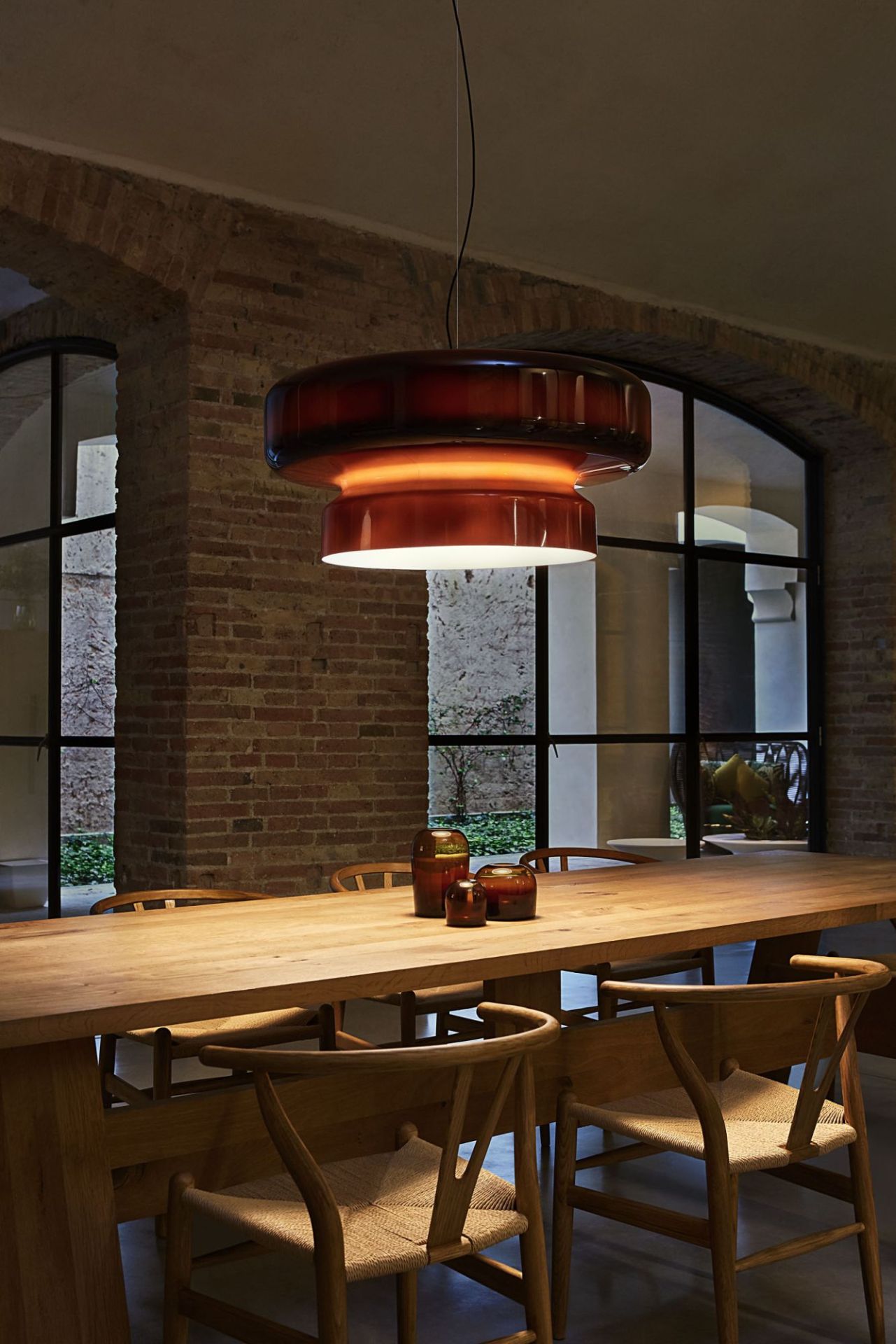 Bohemia Pendelleuchte in Rauchgrau von Marset über Esstisch mit Stühlen. Designlampe.