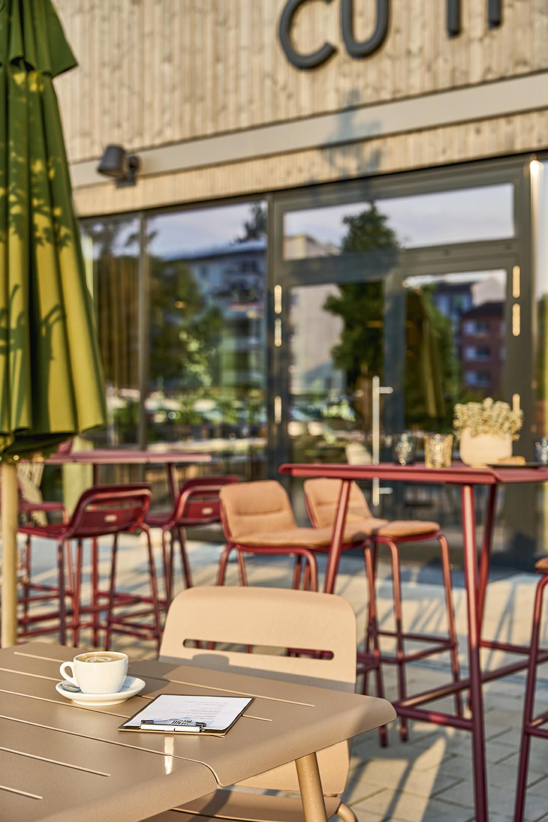 Nahaufnahme eines Vapio Tisch Outdoor von Weishäupl mit Kaffee und Speisekarte, ideal für Gastronomie und Garten.