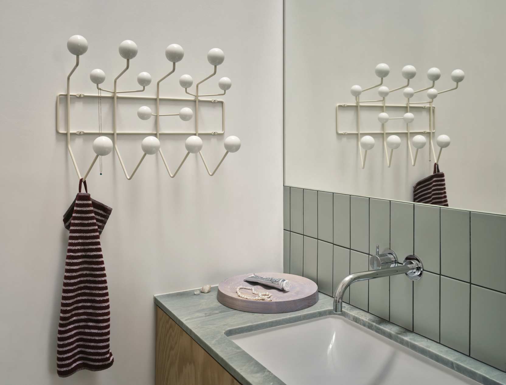 Helle Eames Hang it all Garderobe von Vitra im Badezimmer mit Handtuch und Spiegel.