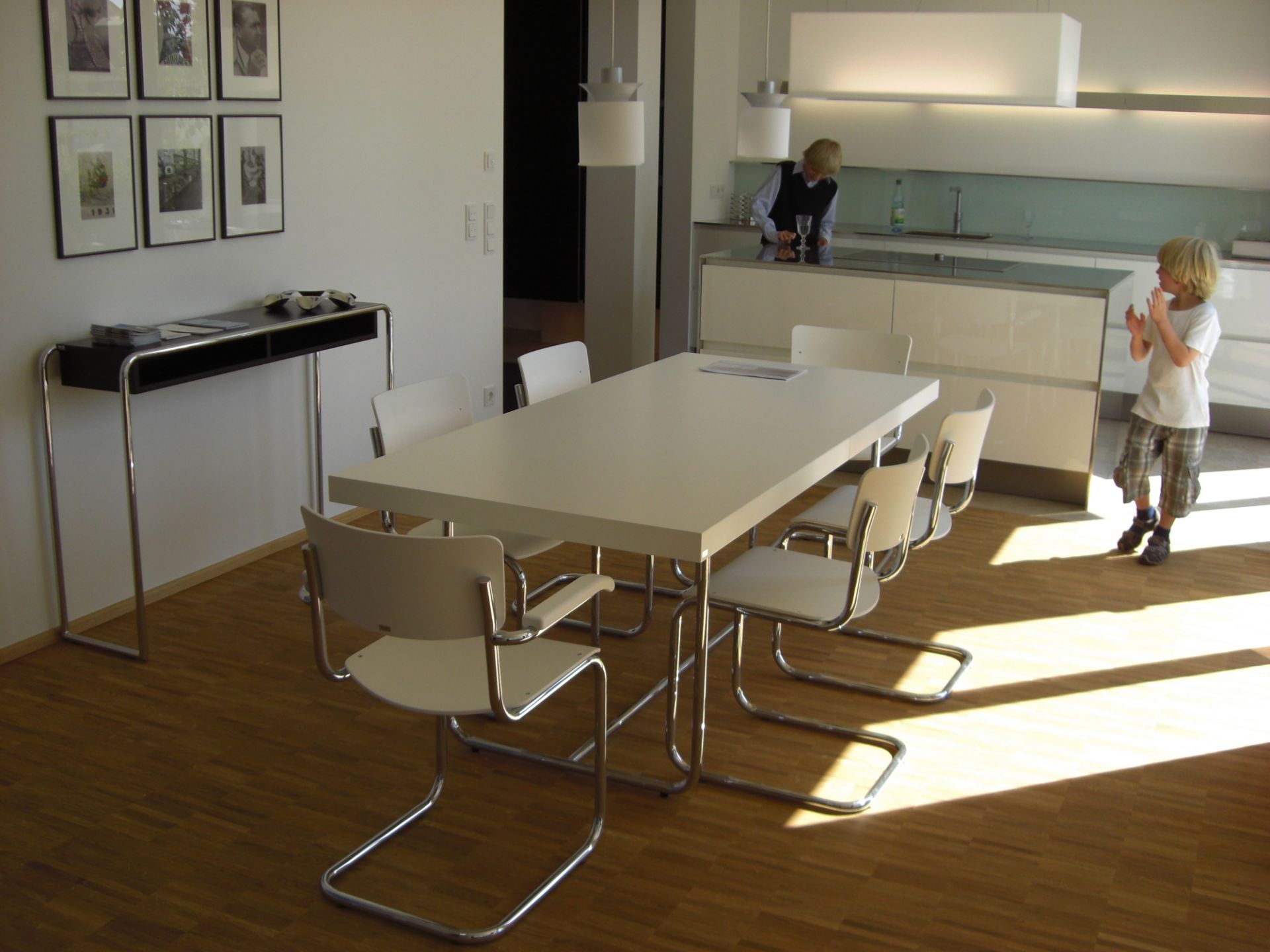 Esszimmer mit Esstisch und sechs weißen Freischwinger Stühlen im Stil von Thonet S 43 Stahlrohr Klassikern.