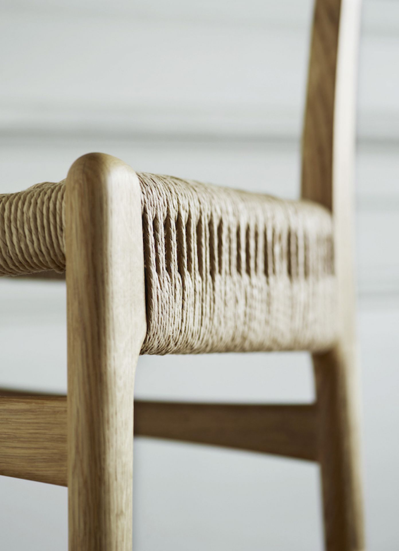 Detailaufnahme des CH23 Stuhls von Carl Hansen & Søn mit schwarzer Kordel und Eichenholz.
