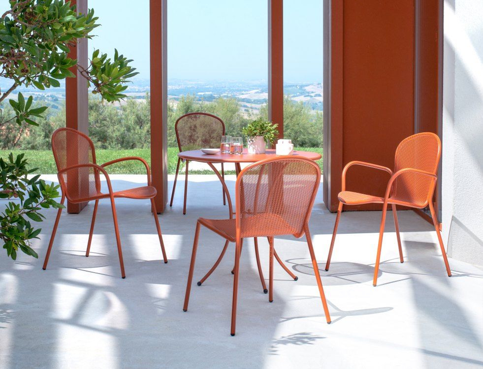 Orangefarbene Emu Ronda X Stühle und Tisch für den Außenbereich auf einer Terrasse.
