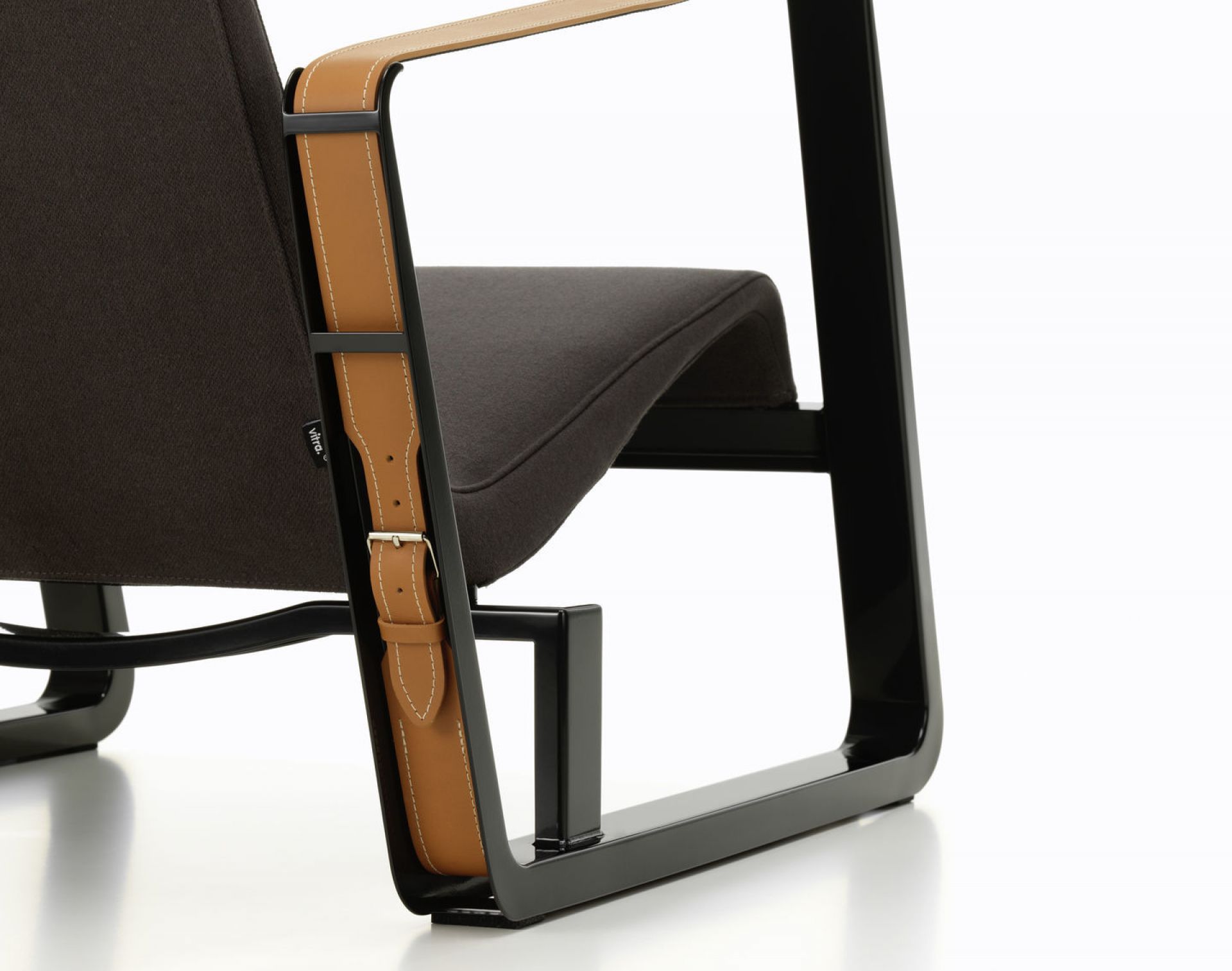 Detailansicht des Vitra Cité Sessels mit braunem Stoffbezug und Lederarmlehnen, modernes Möbeldesign für Wohnzimmer und Büro.