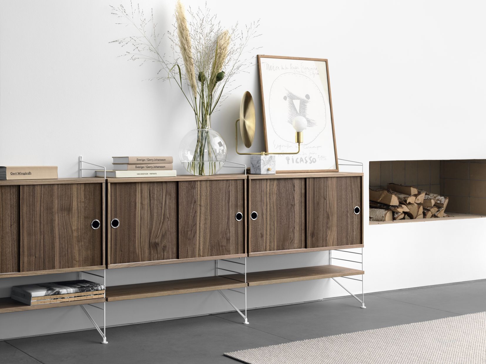 String Regalsystem mit Walnuss-Schrankelementen und weißen Leitern. Wohnzimmer Einrichtung mit String Furniture.