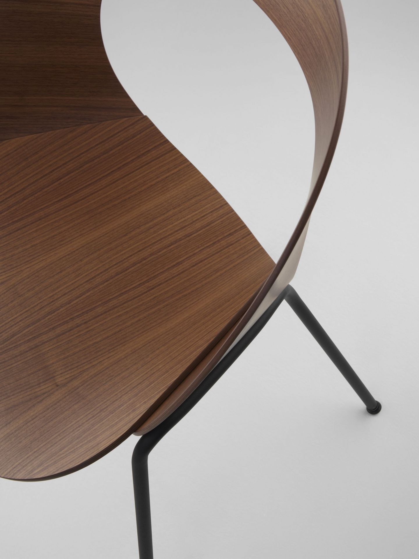 Detailaufnahme des Brunner Mudra Stuhls mit Holzschale und schwarzem Metallgestell, modernes Möbeldesign.