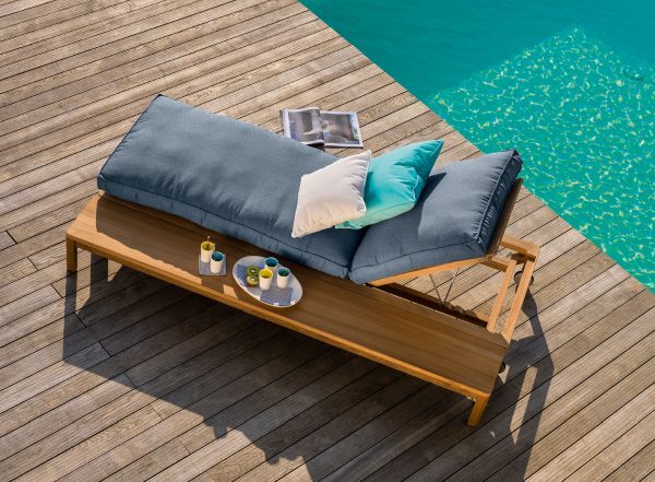 New Hampton Sonnenliege Outdoor Weishäupl aus Holz mit blauen Kissen am Pool für entspannte Stunden.