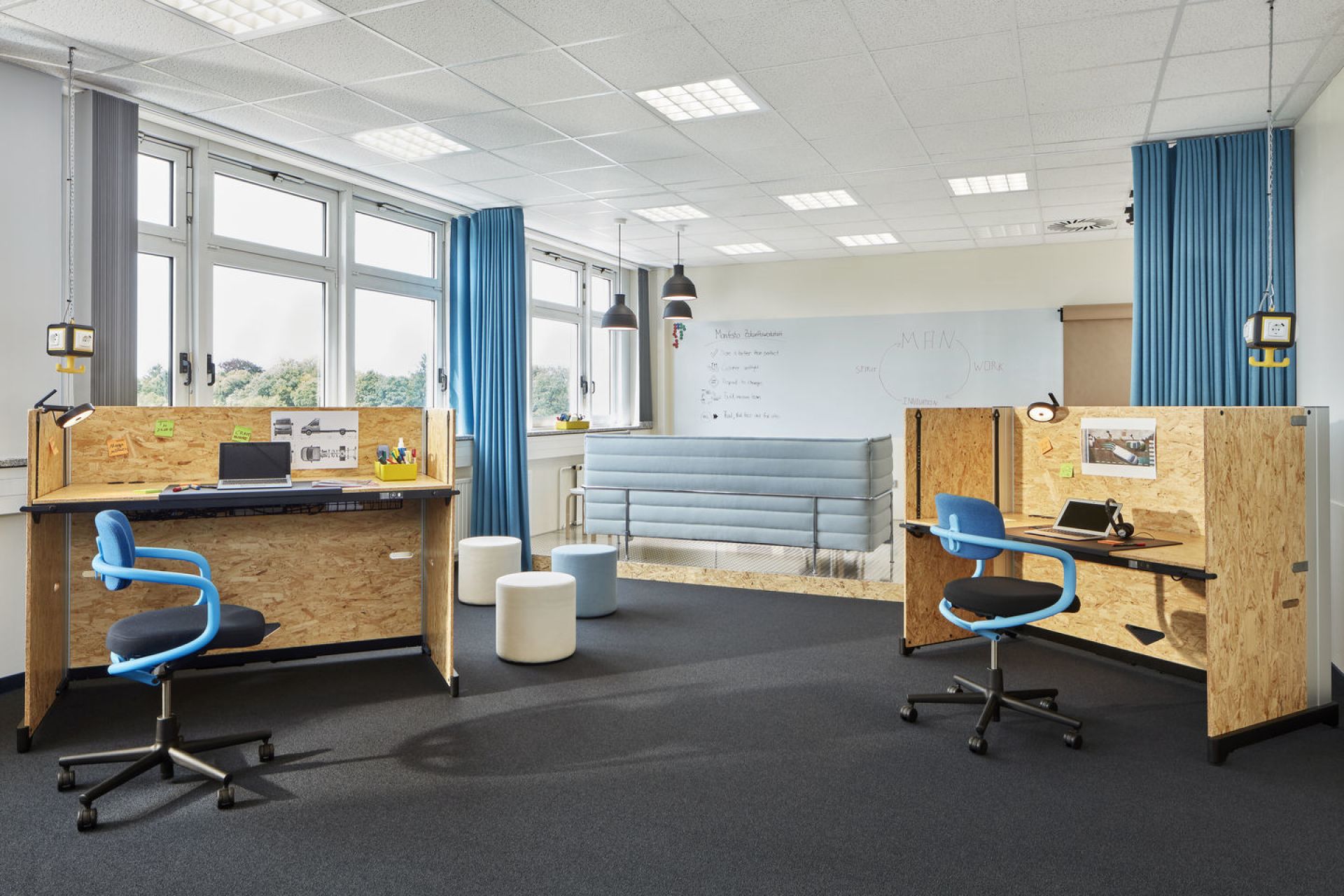 Büro mit zwei Allstar Bürodrehstühlen von Vitra, Schreibtischen und blauen Vorhängen für moderne Arbeitsplätze.