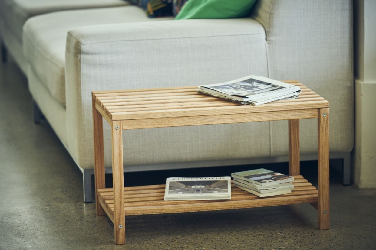 Bankier Bank Jan Kurtz aus hellem Holz mit Ablage und Zeitschriften neben einem Sofa.