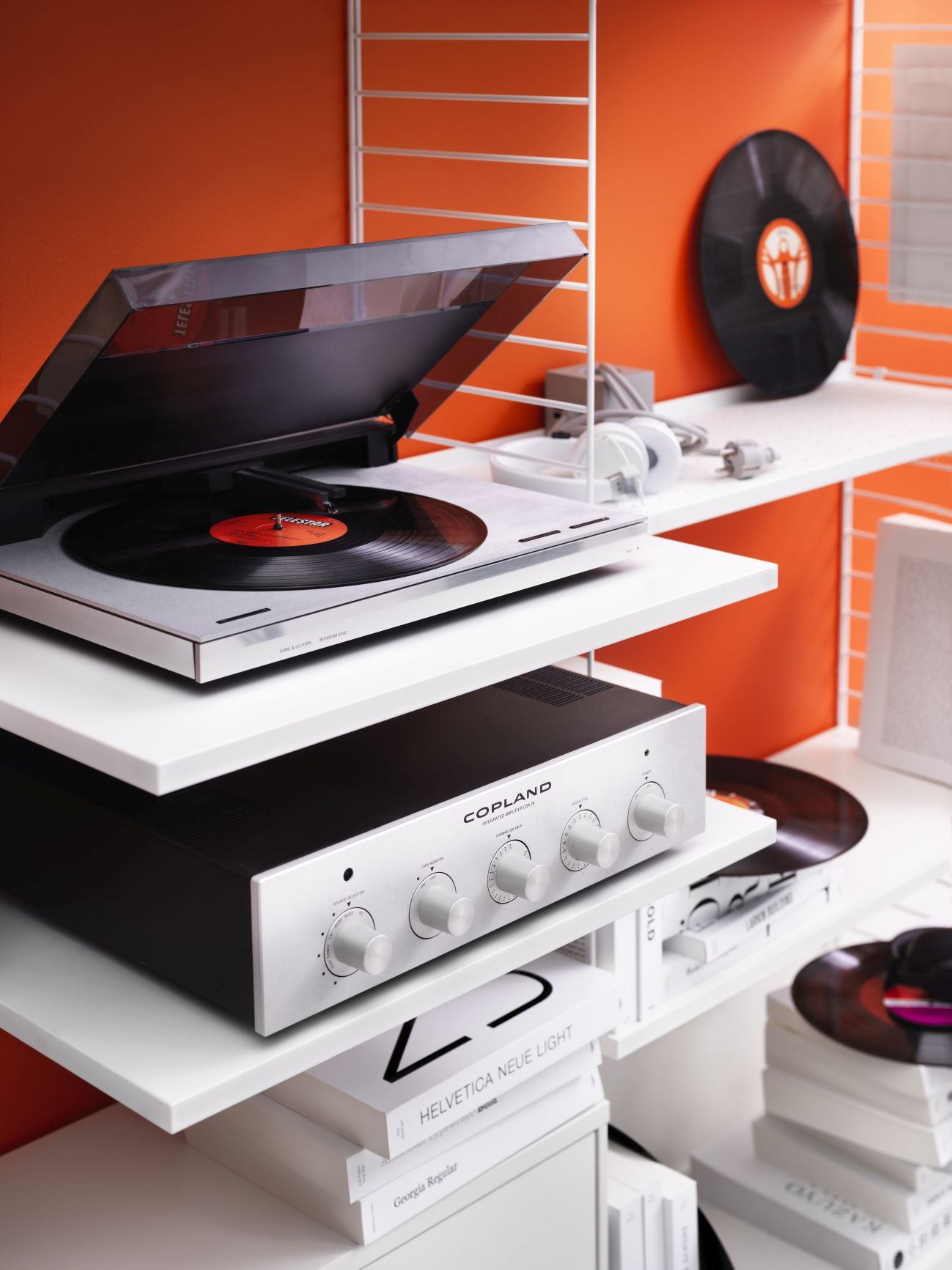 Weißes String Regalsystem mit Plattenspieler, Verstärker und Schallplatten. Modernes Wandregal für Wohnzimmer und Musikliebhaber.
