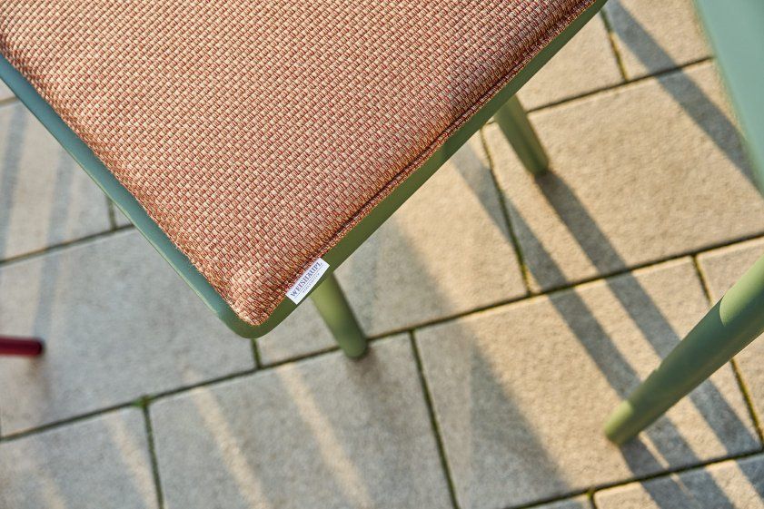 Detailaufnahme der Weishäupl Vapio Bank Outdoor Sitzfläche mit braunem Stoffbezug und grünem Gestell.